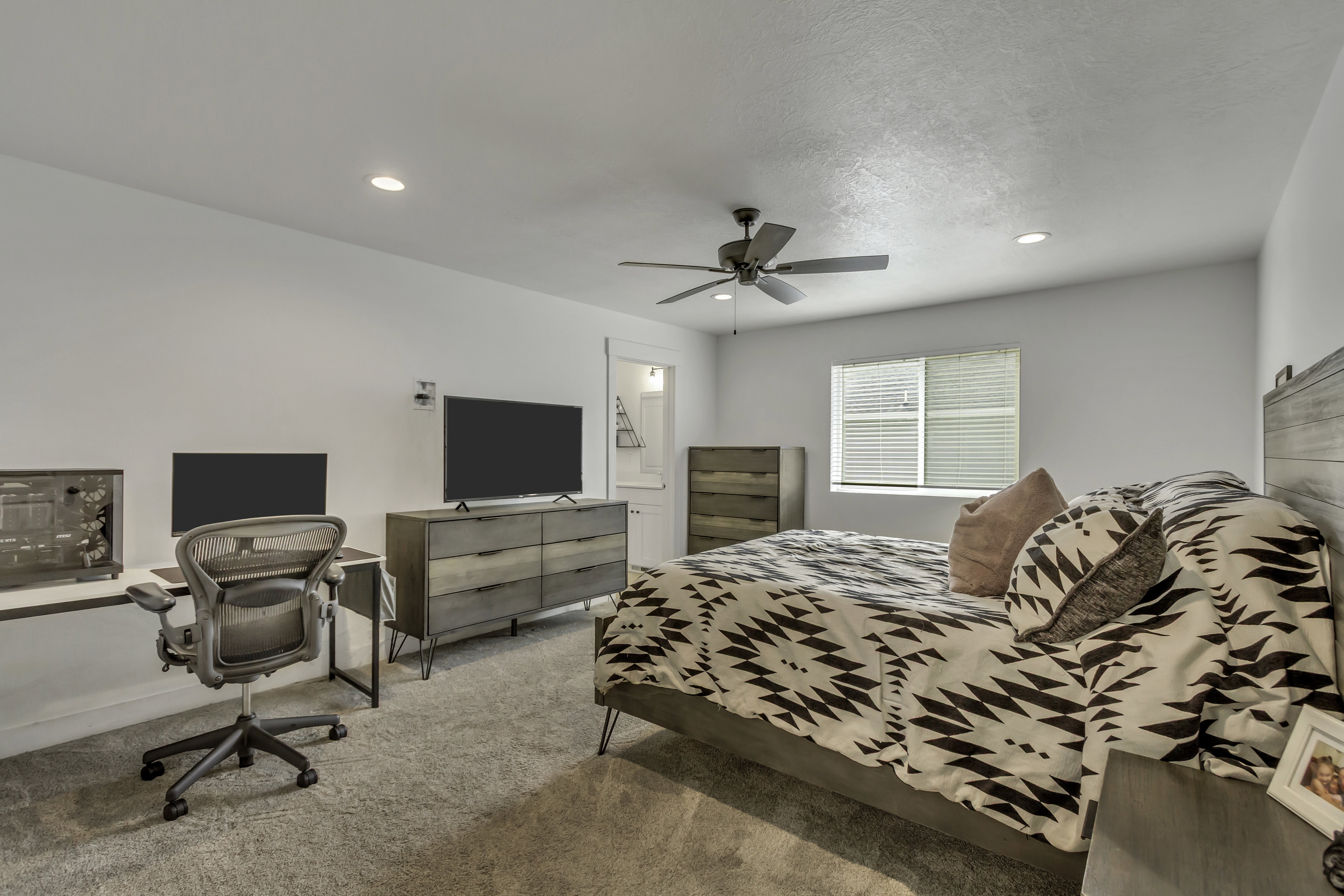 Spacious room featuring neutral carpeting, recessed lighting, and a ceiling fan