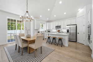 Open-concept kitchen and dining area with light wood-finish flooring