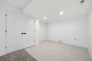 Bright, open room featuring recessed lighting, light-toned flooring, and white walls
