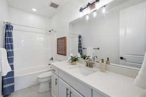 Contemporary bathroom featuring a single vanity with light-colored cabinetry, a spacious countertop, and an undermount sink