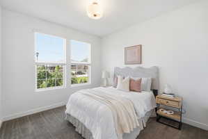 Bedroom featuring neutral carpeting, white walls, and a contemporary ceiling light fixture