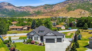 Contemporary home with a dark shingle roof, solar panels, a two-car garage, and a manicured front lawn