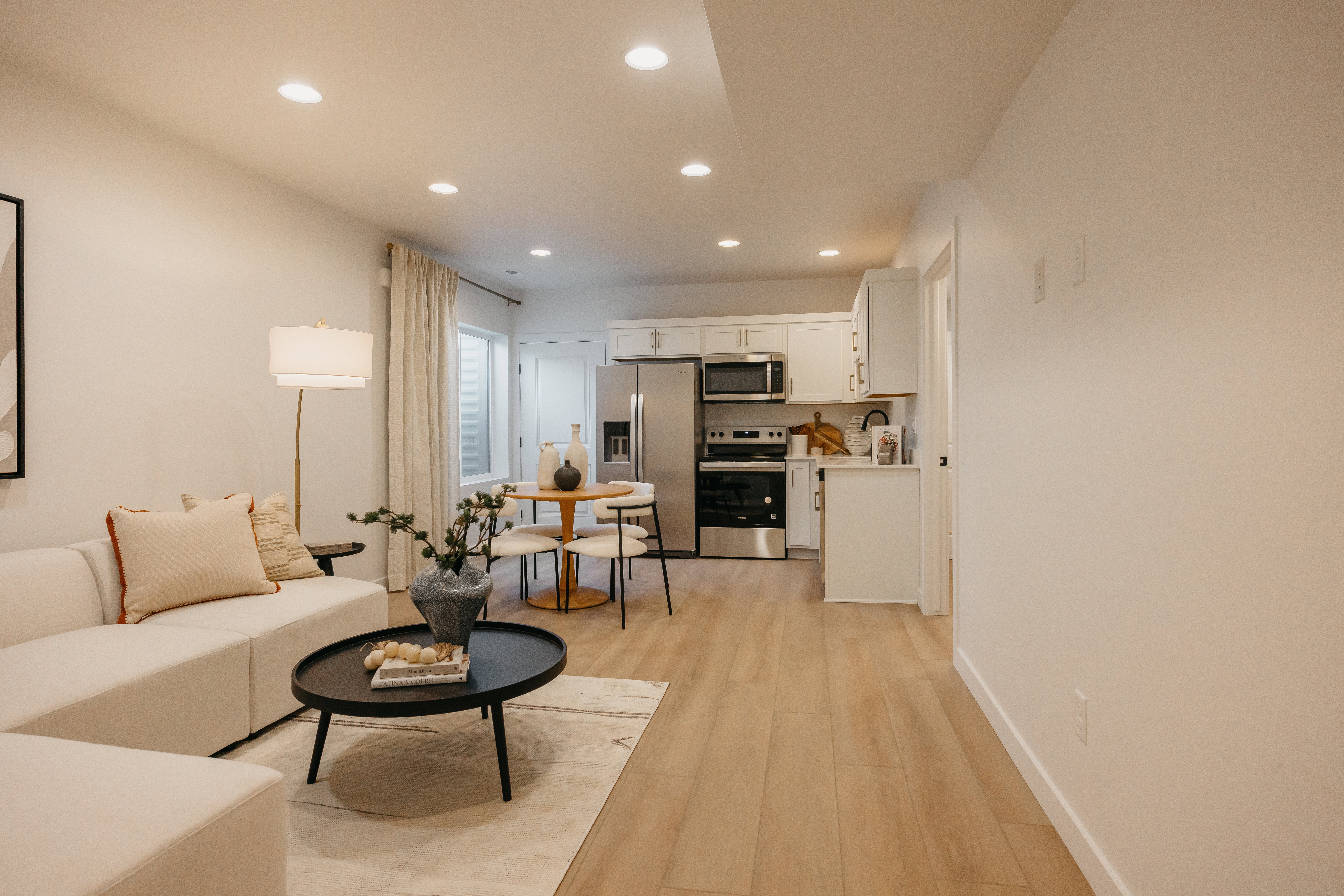Open-concept living space featuring wood-finish flooring, recessed lighting, and a modern kitchen