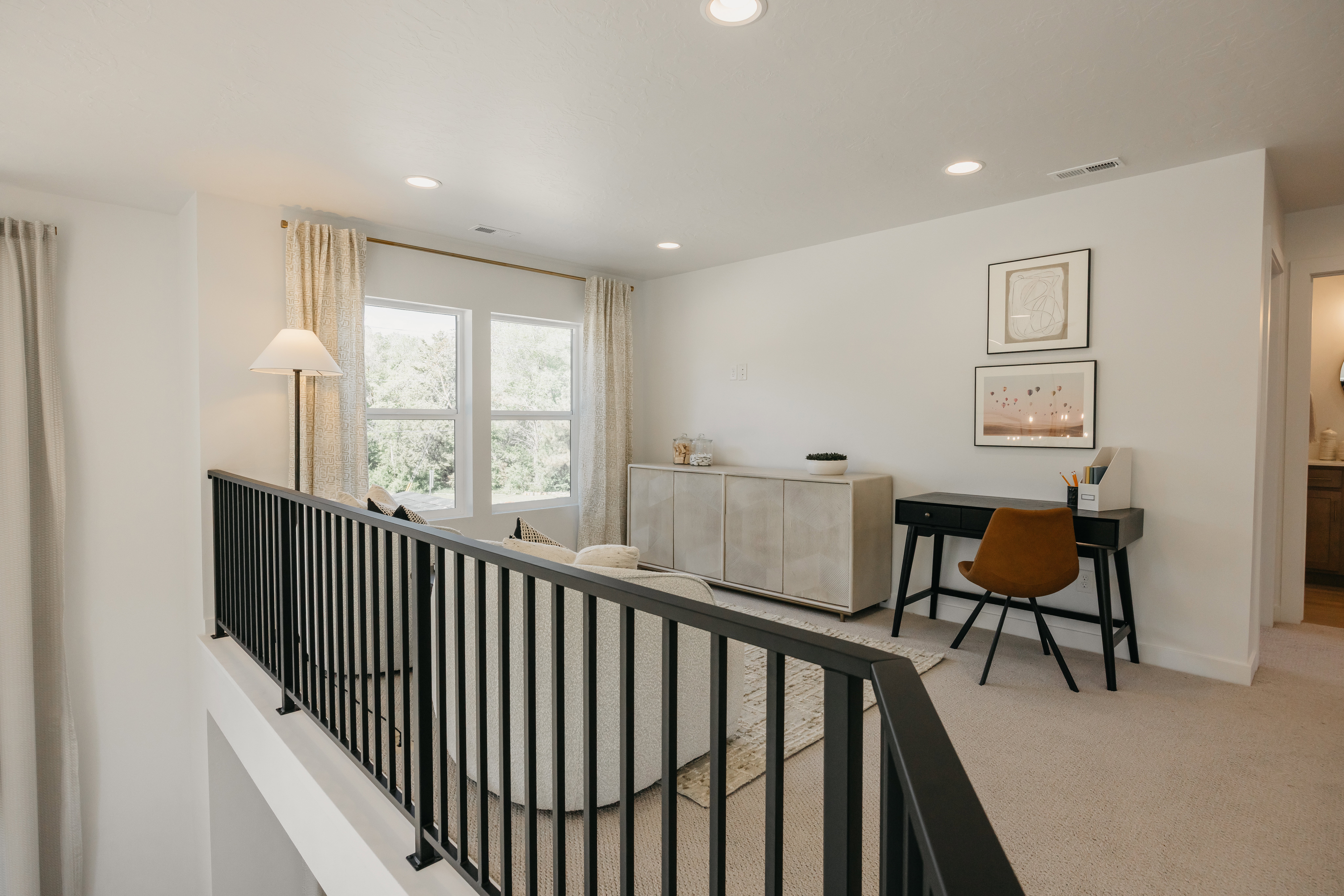 Upper-level landing featuring a black metal railing