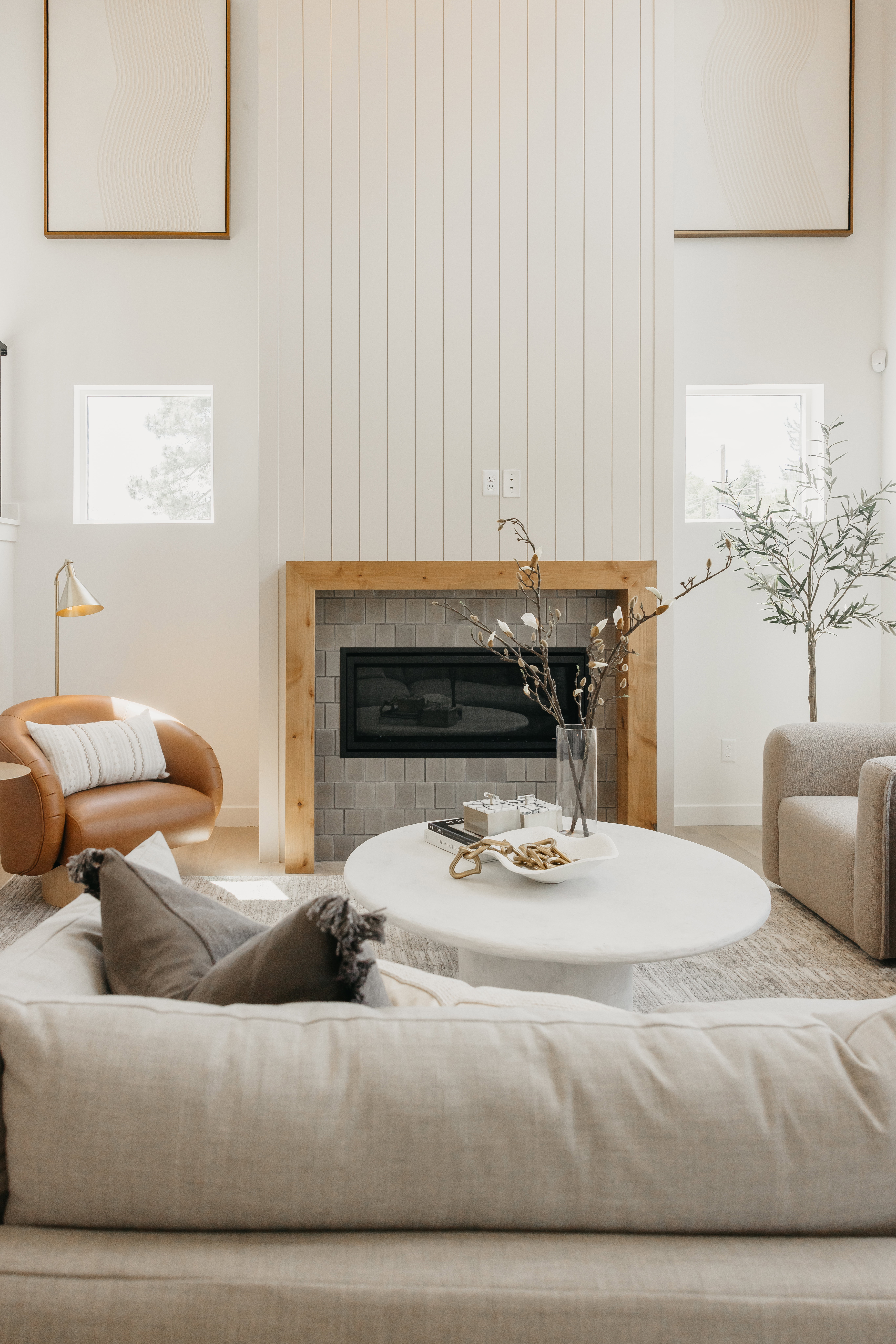 Soaring ceilings above a fireplace featuring wood-finish trim and gray tile surround