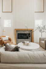 Soaring ceilings above a fireplace featuring wood-finish trim and gray tile surround