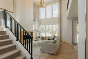 Two-story living area featuring a vaulted ceiling and a prominent fireplace with a wood mantel
