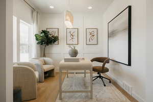 Bright room featuring light wood-finish flooring, recessed lighting, and a window with sheer drapes
