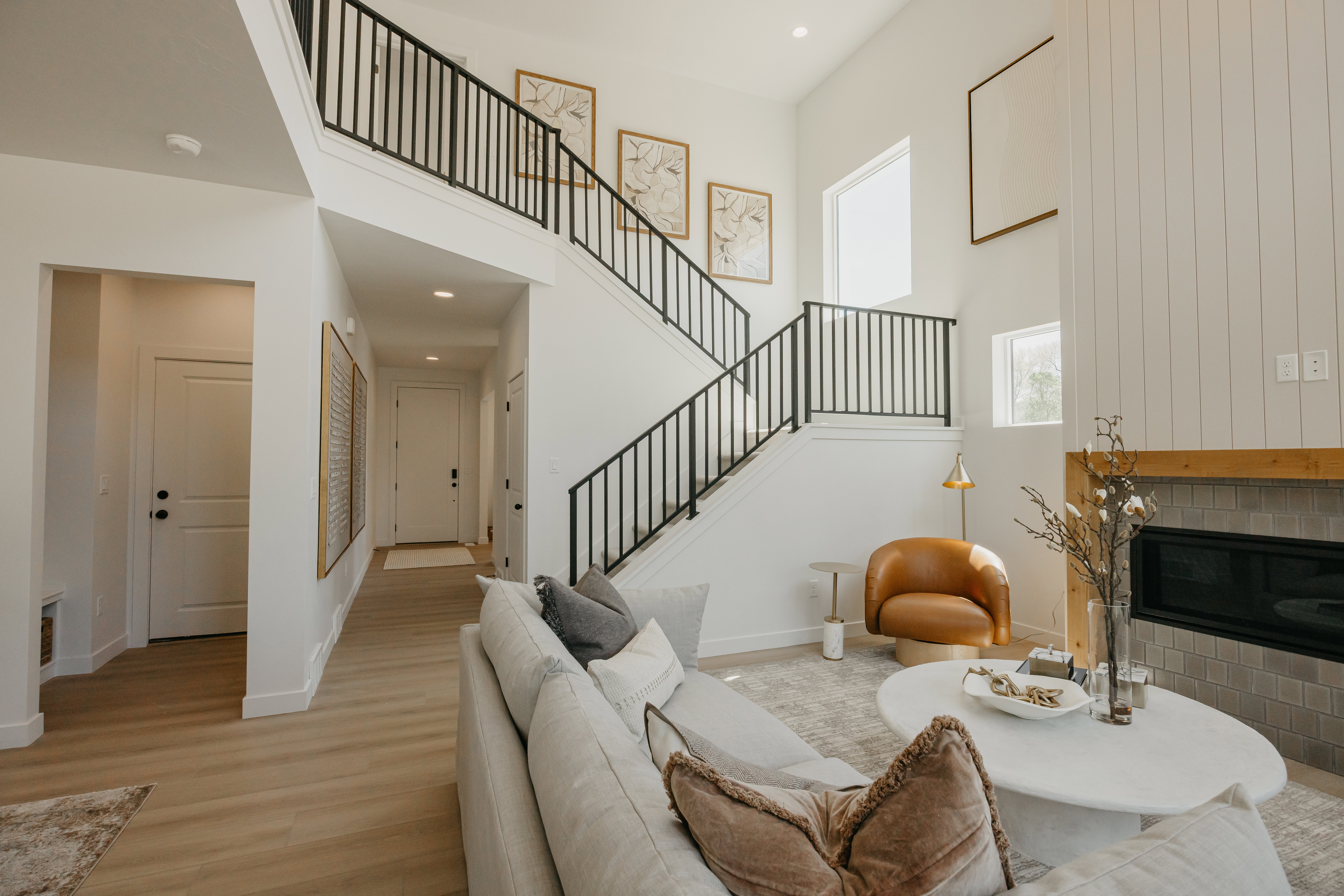 Vaulted ceiling living space featuring a two-story fireplace with a wooden mantle and tiled surround
