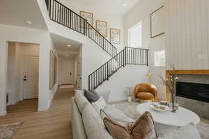 Vaulted ceiling living space featuring a two-story fireplace with a wooden mantle and tiled surround