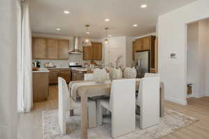 Open-concept kitchen and dining area featuring light wood-finish flooring, recessed lighting, and pendant lighting fixtures
