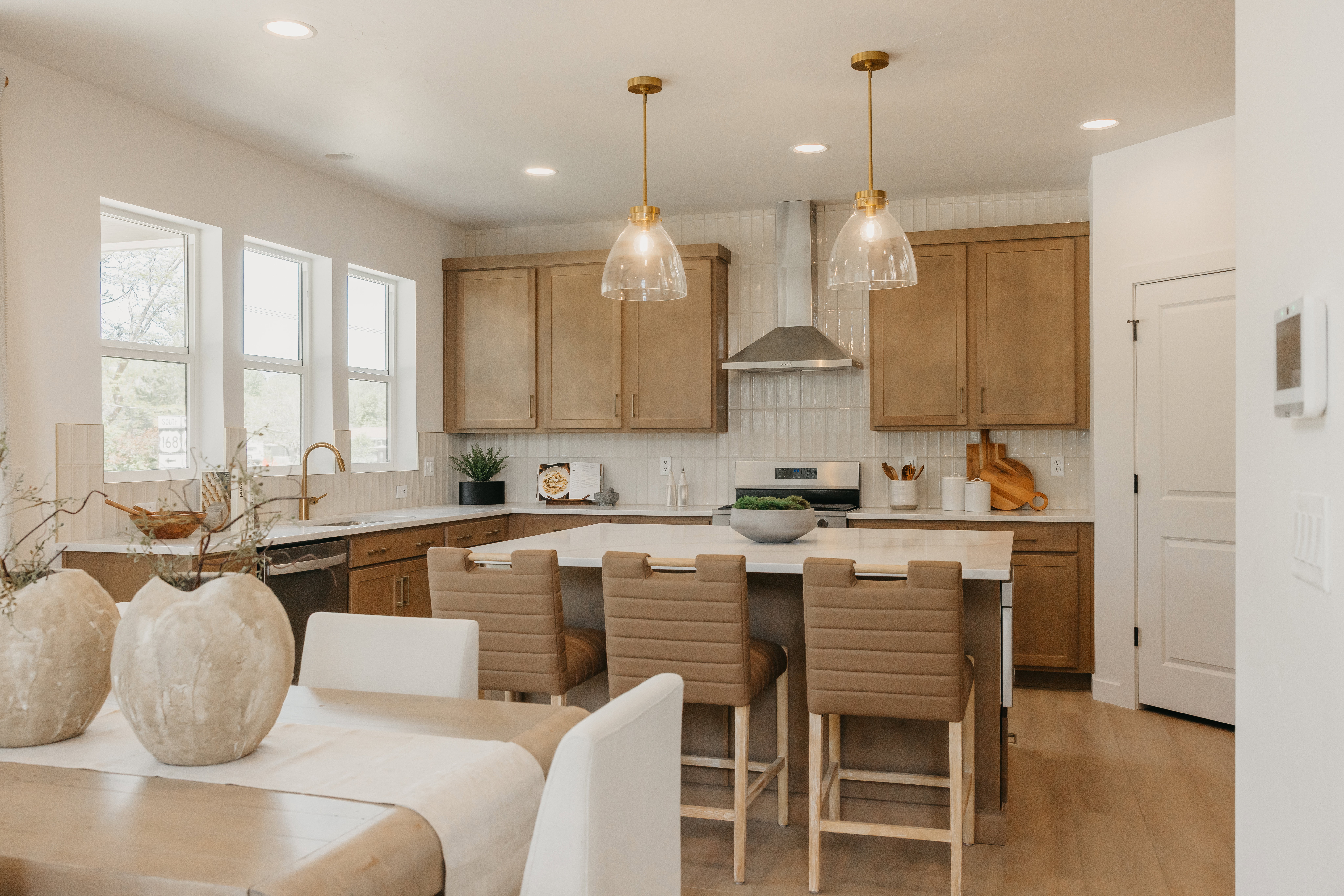 Open-concept kitchen featuring an island with seating, pendant lighting, stainless steel appliances, and wood-finish cabinetry
