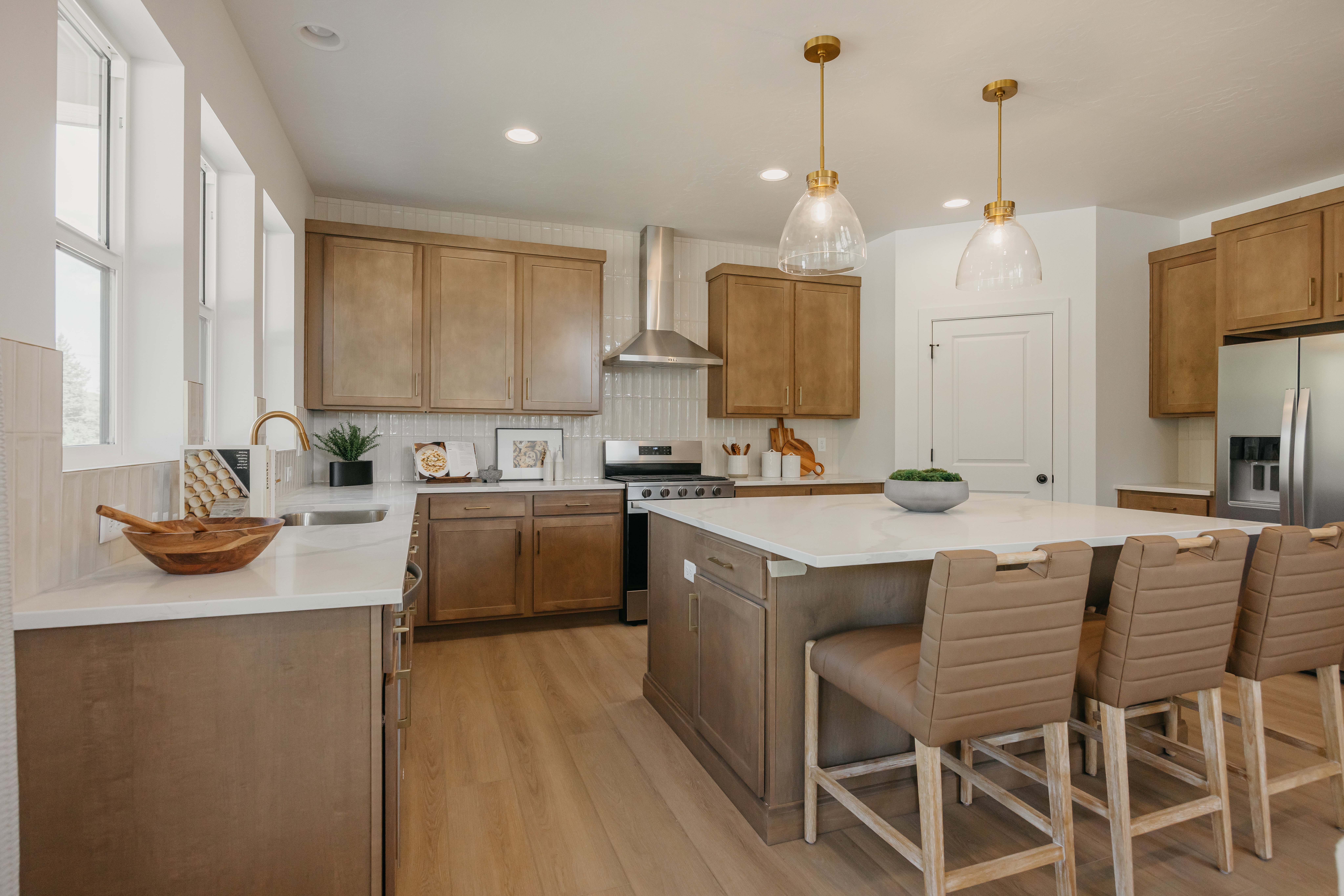 Gourmet kitchen with a large central island, light wood-finish flooring, recessed lighting, and stainless steel appliances