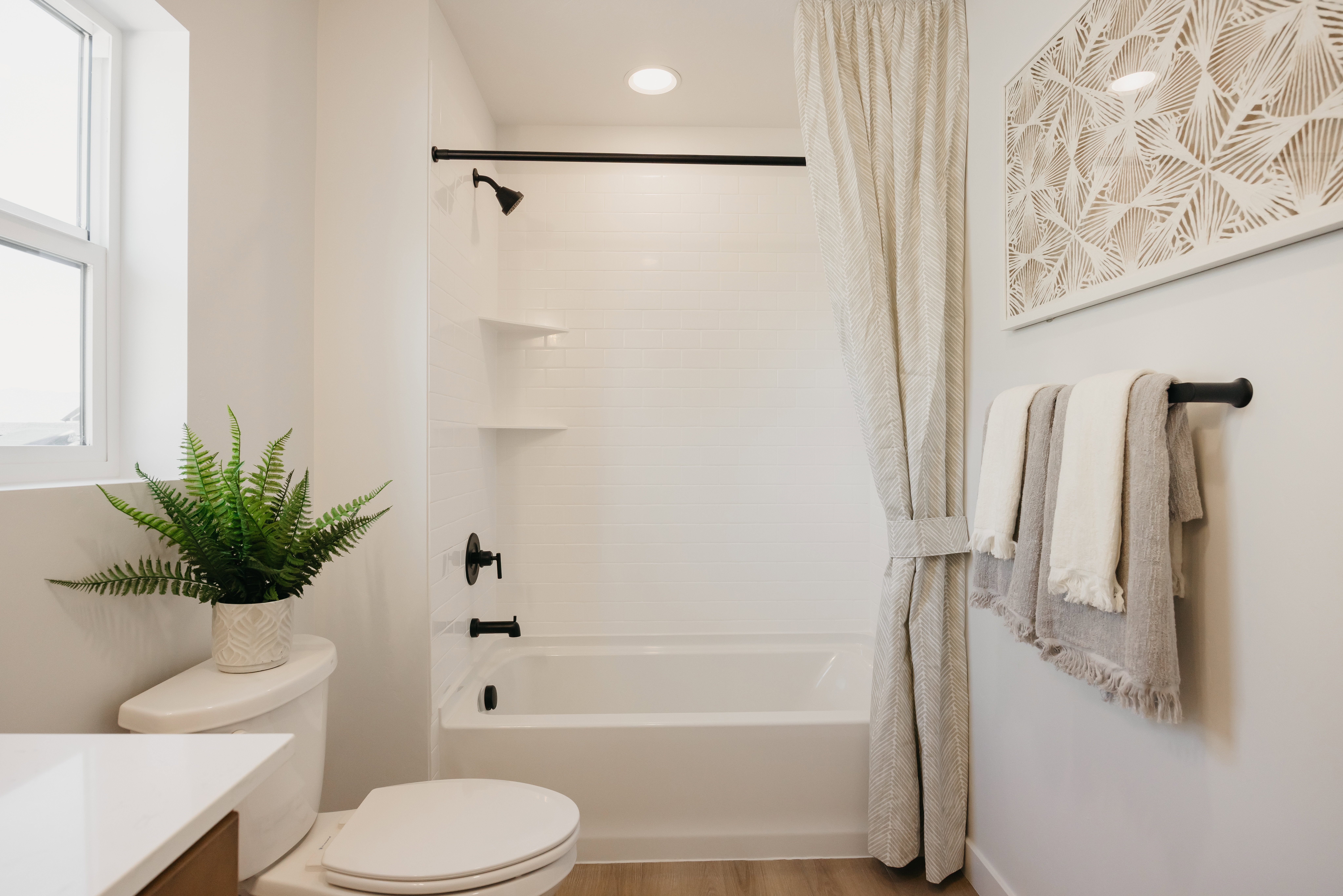 Bathroom featuring a white bathtub and shower combination with black fixtures