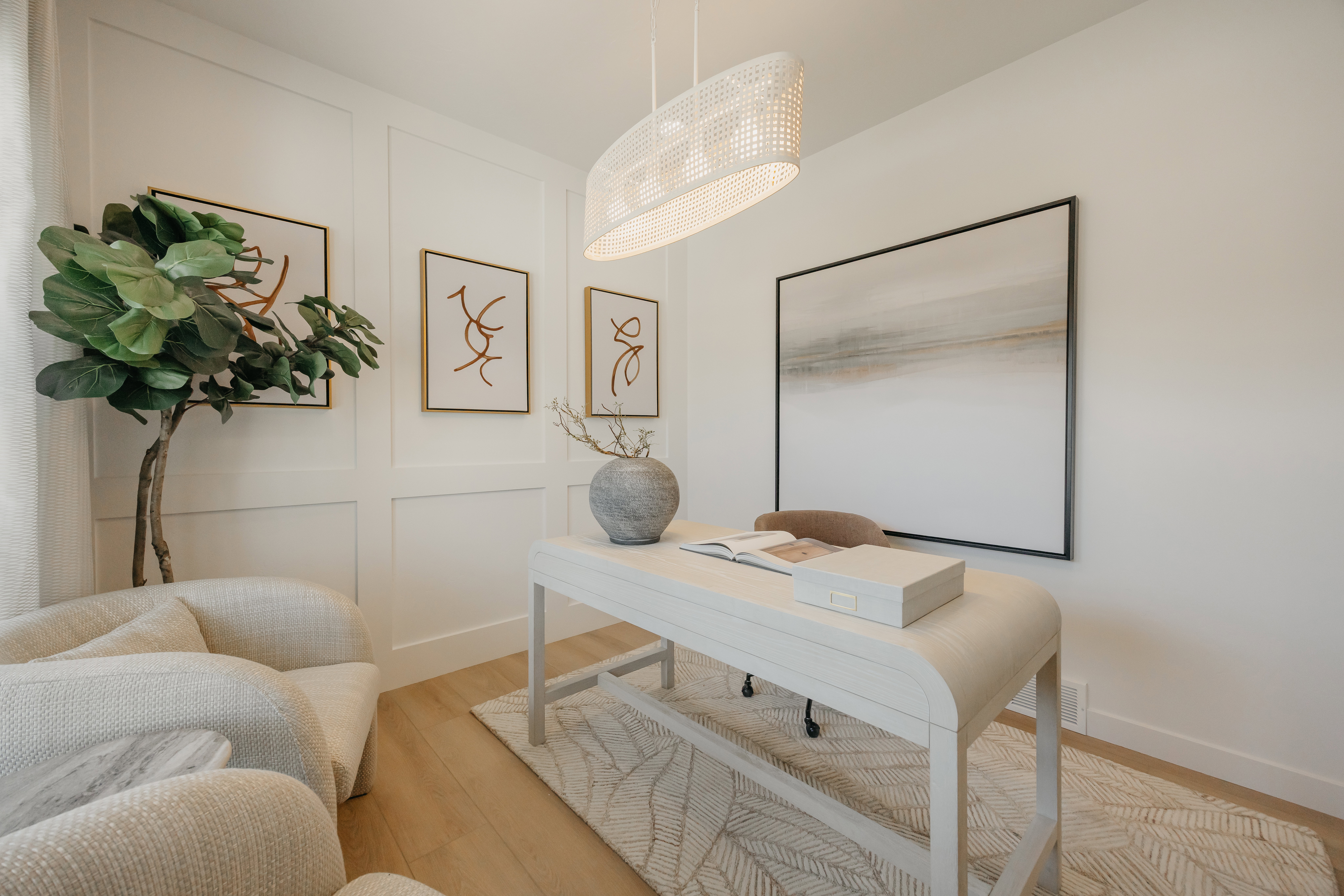 Office space featuring light wood-finish flooring, white panel accent wall, and recessed baseboards
