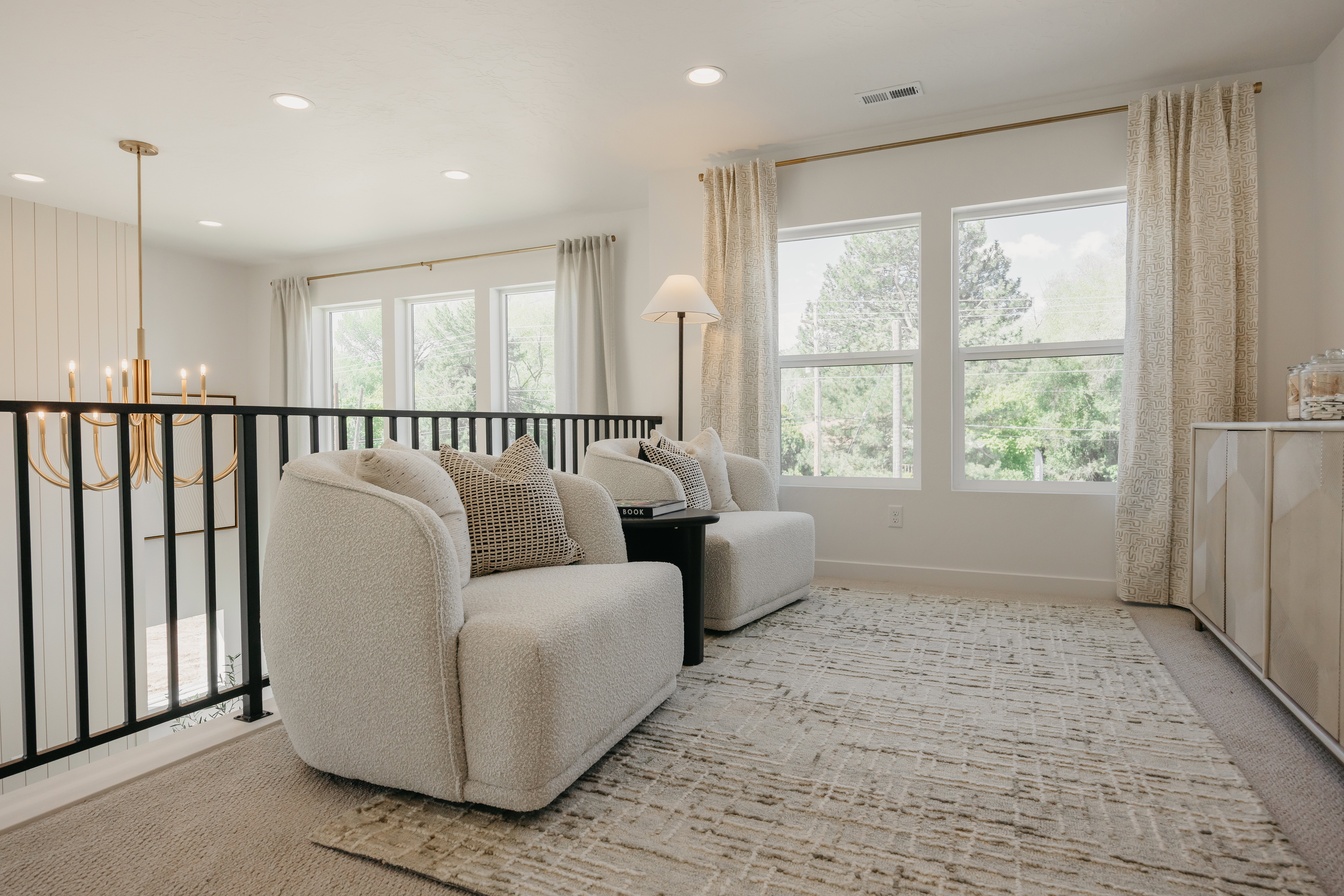 Open loft area featuring multiple windows, a gold-toned chandelier, shiplap accent wall, and recessed lighting
