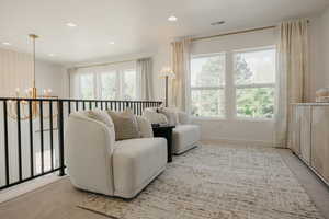 Open loft area featuring multiple windows, a gold-toned chandelier, shiplap accent wall, and recessed lighting