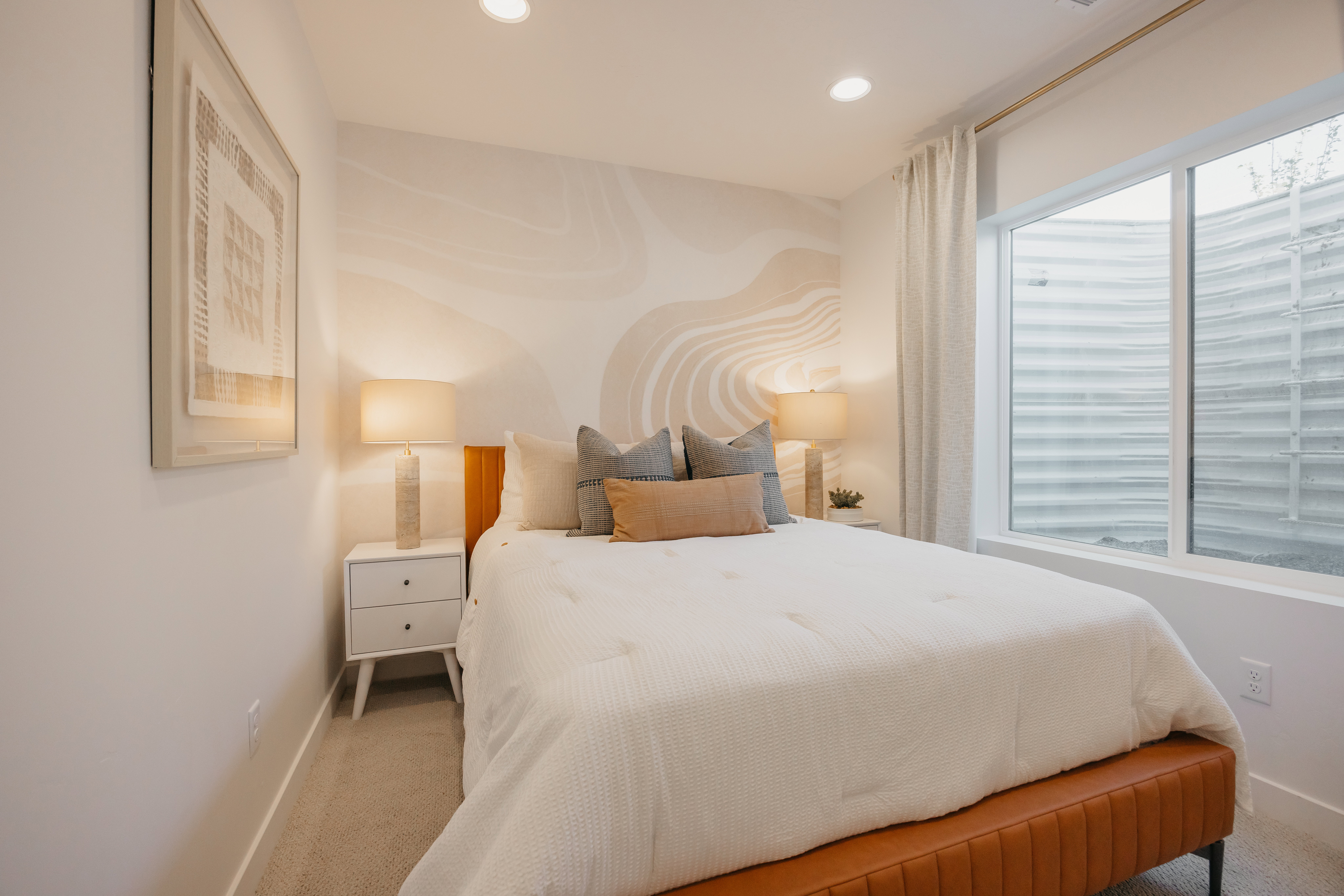 Spacious bedroom featuring recessed lighting, a large egress window, and a decorative wall accent