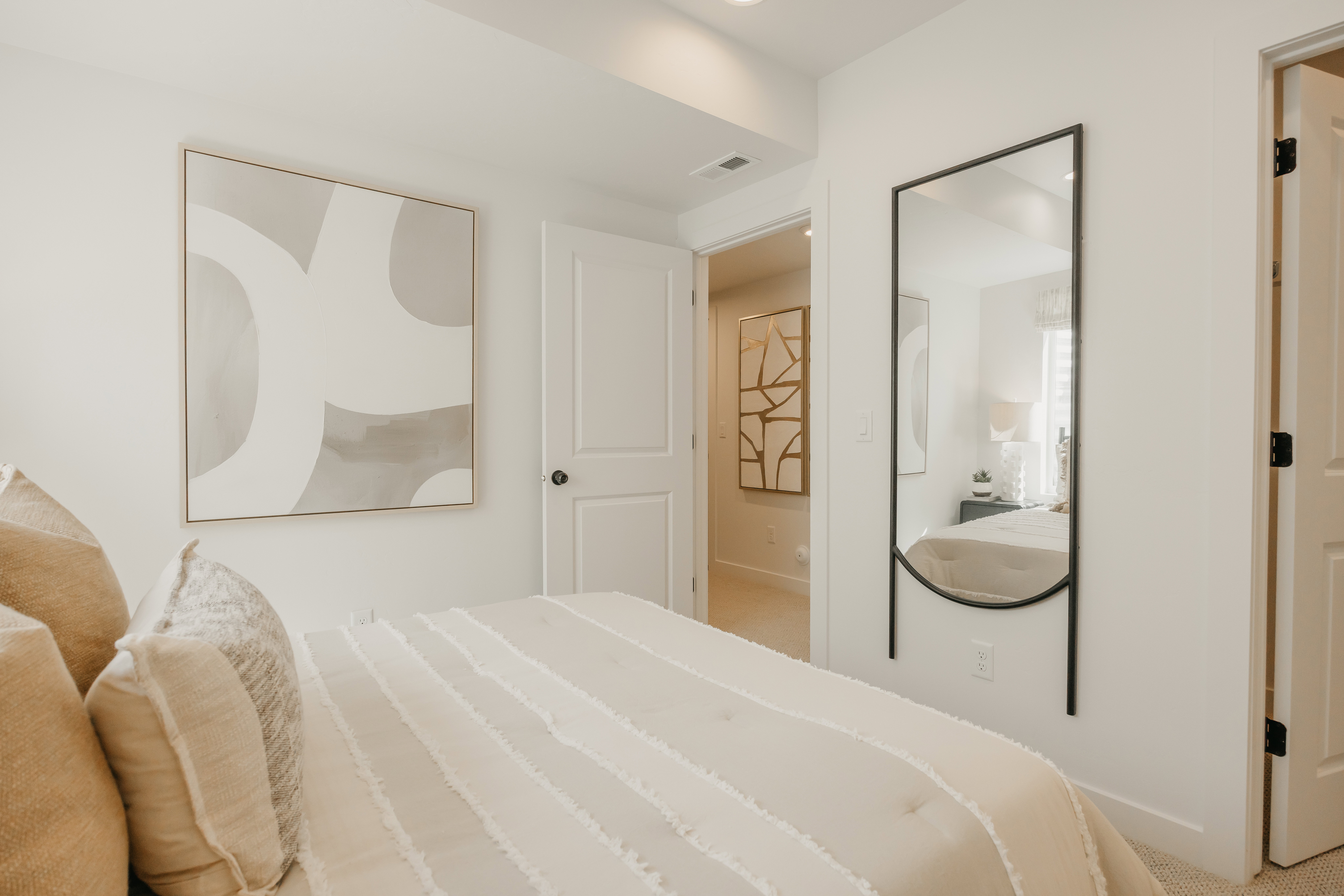 Clean bedroom space featuring light-colored walls and carpet flooring