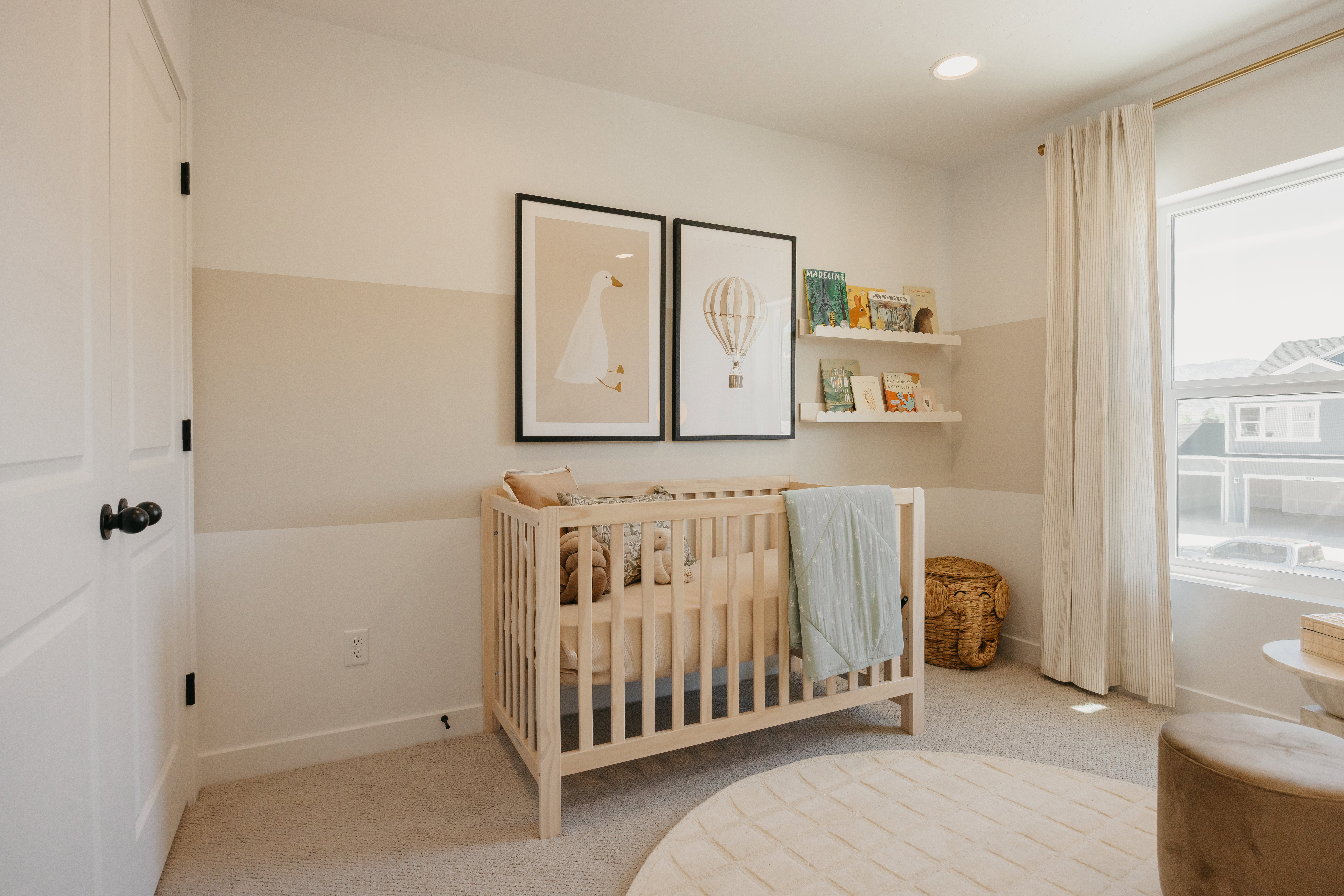Spacious room featuring neutral paint with a horizontal accent stripe, recessed lighting, and a large window with ample natural light