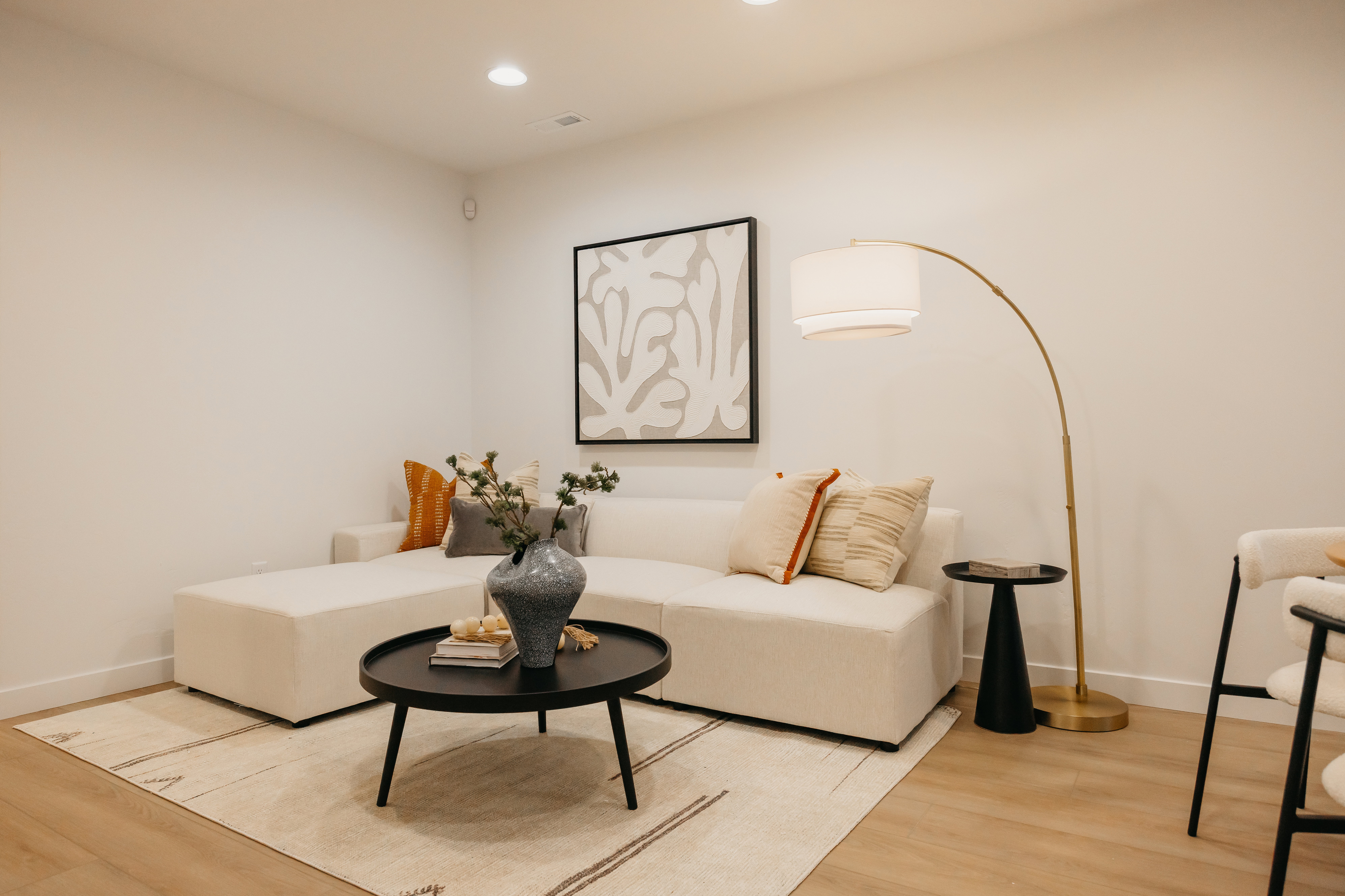 Recessed ceiling lighting illuminates the light-toned walls and wood-finish flooring