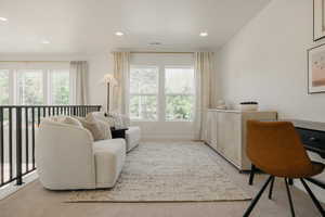 Open concept loft space featuring a black metal railing