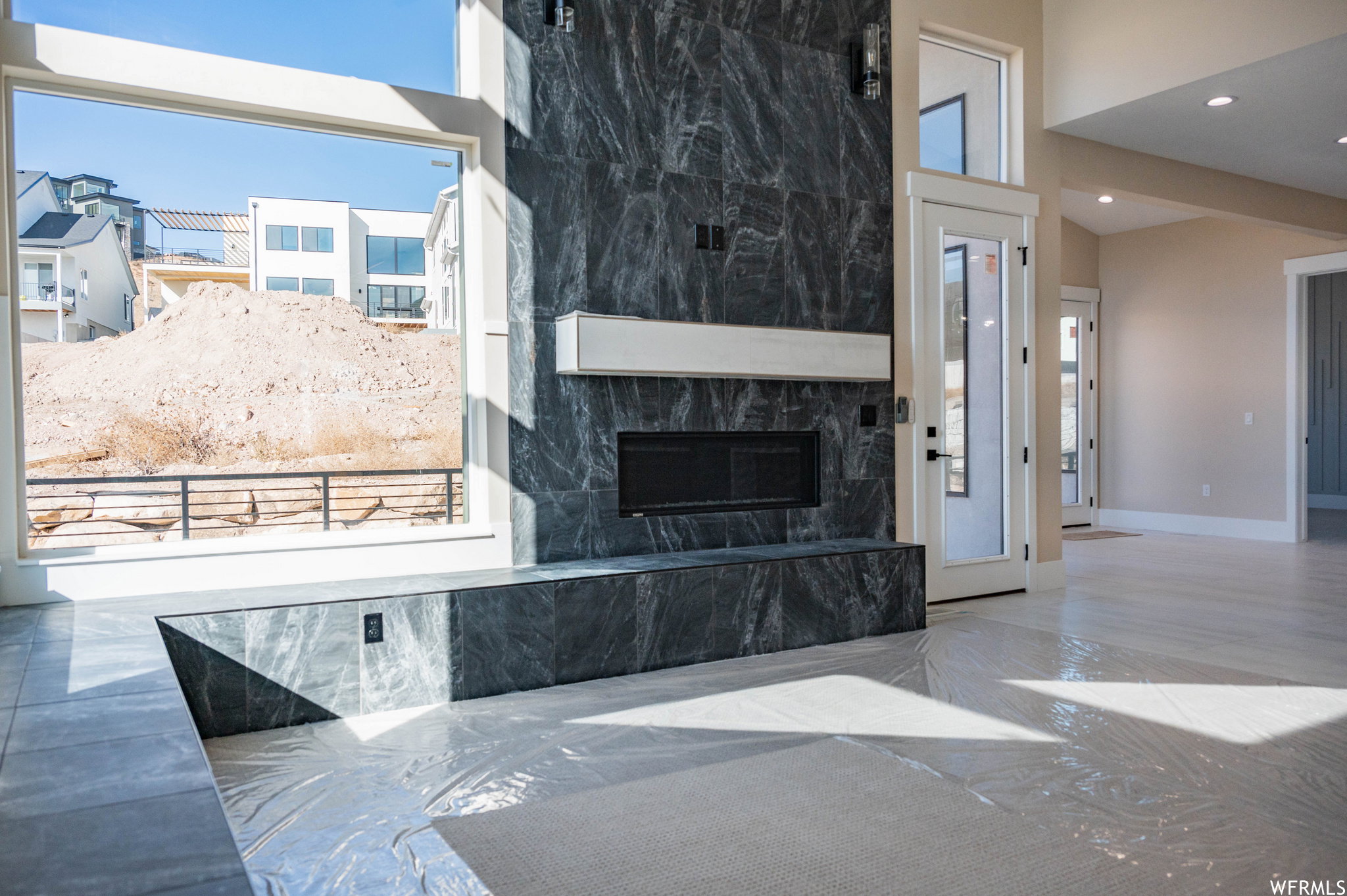Expansive great room featuring a floor-to-ceiling fireplace with dark stone-finish cladding and an integrated linear firebox