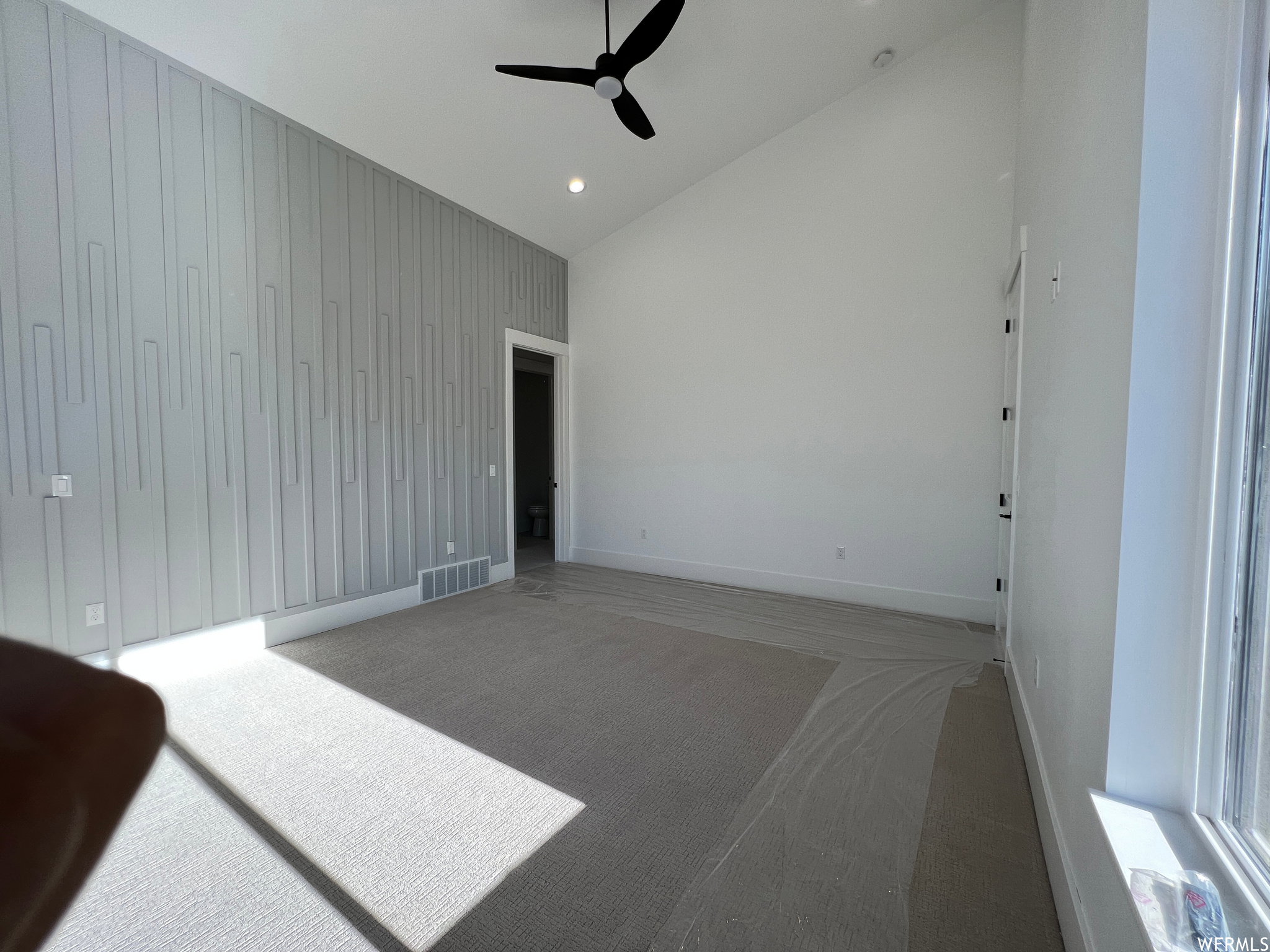 Vaulted ceiling with a black ceiling fan and recessed lighting