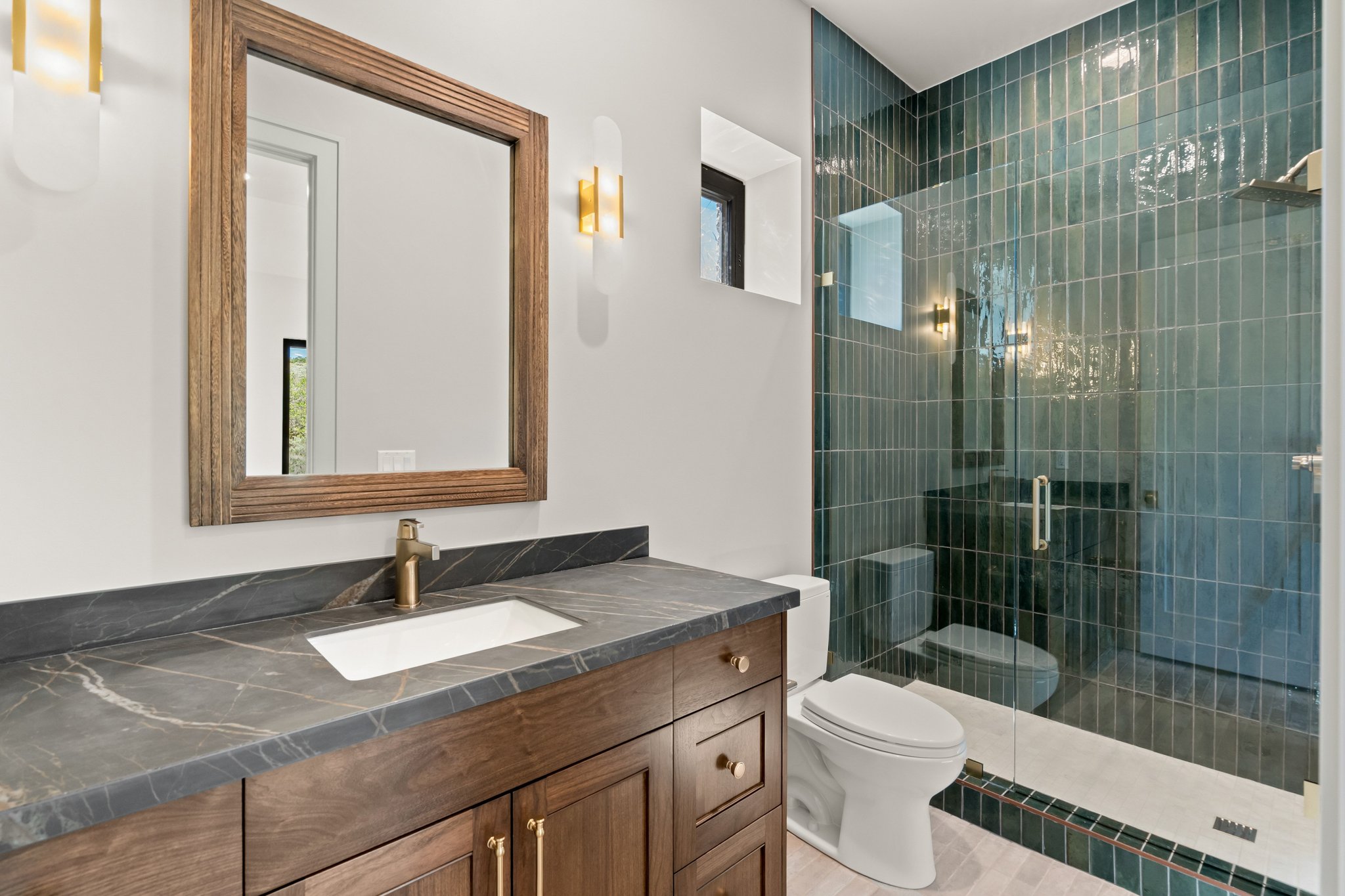 Bathroom featuring a wood-finish vanity with a dark countertop and integrated sink