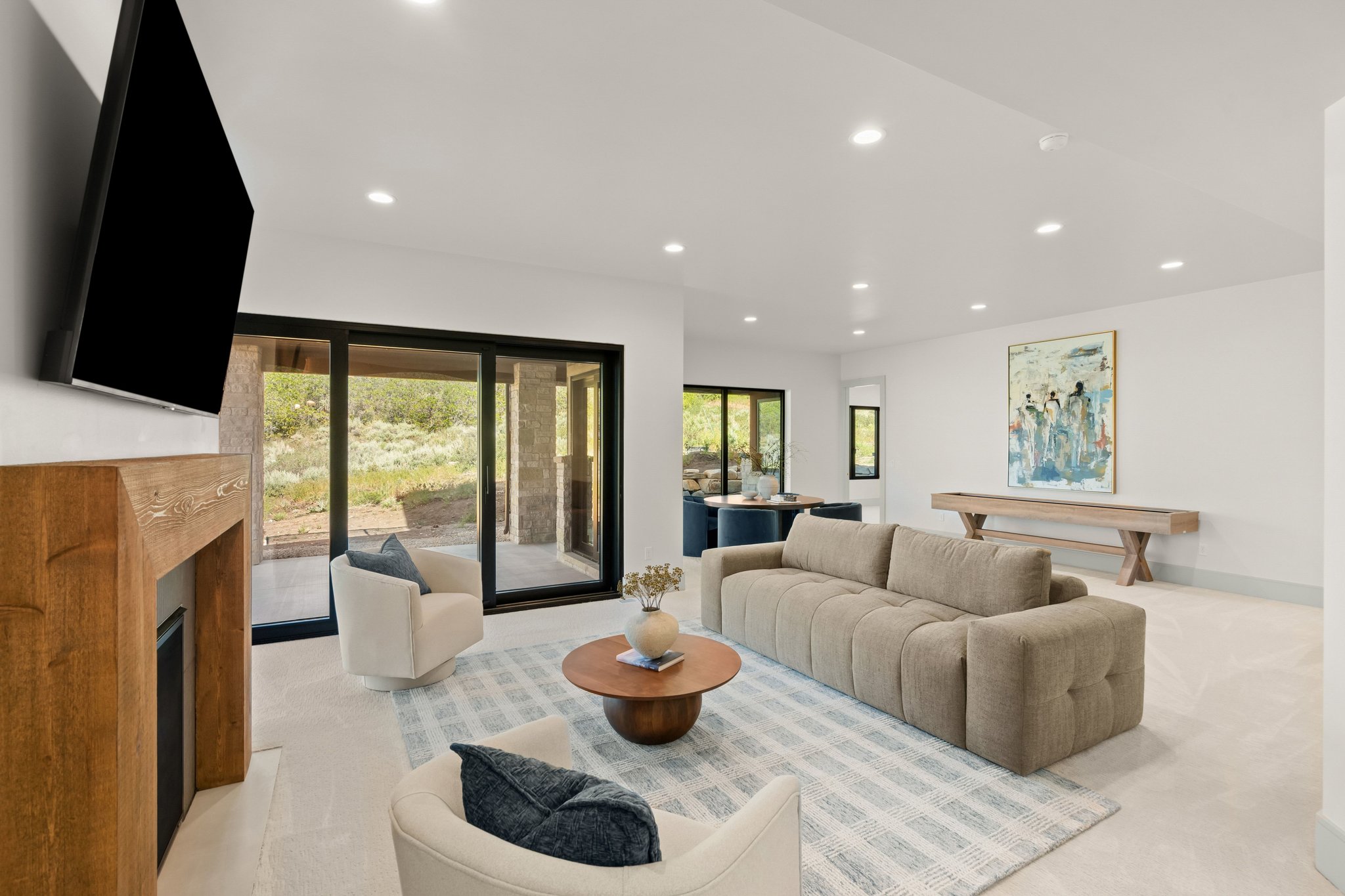 Spacious living area featuring a fireplace with a wood mantle, recessed lighting, and expansive sliding glass doors