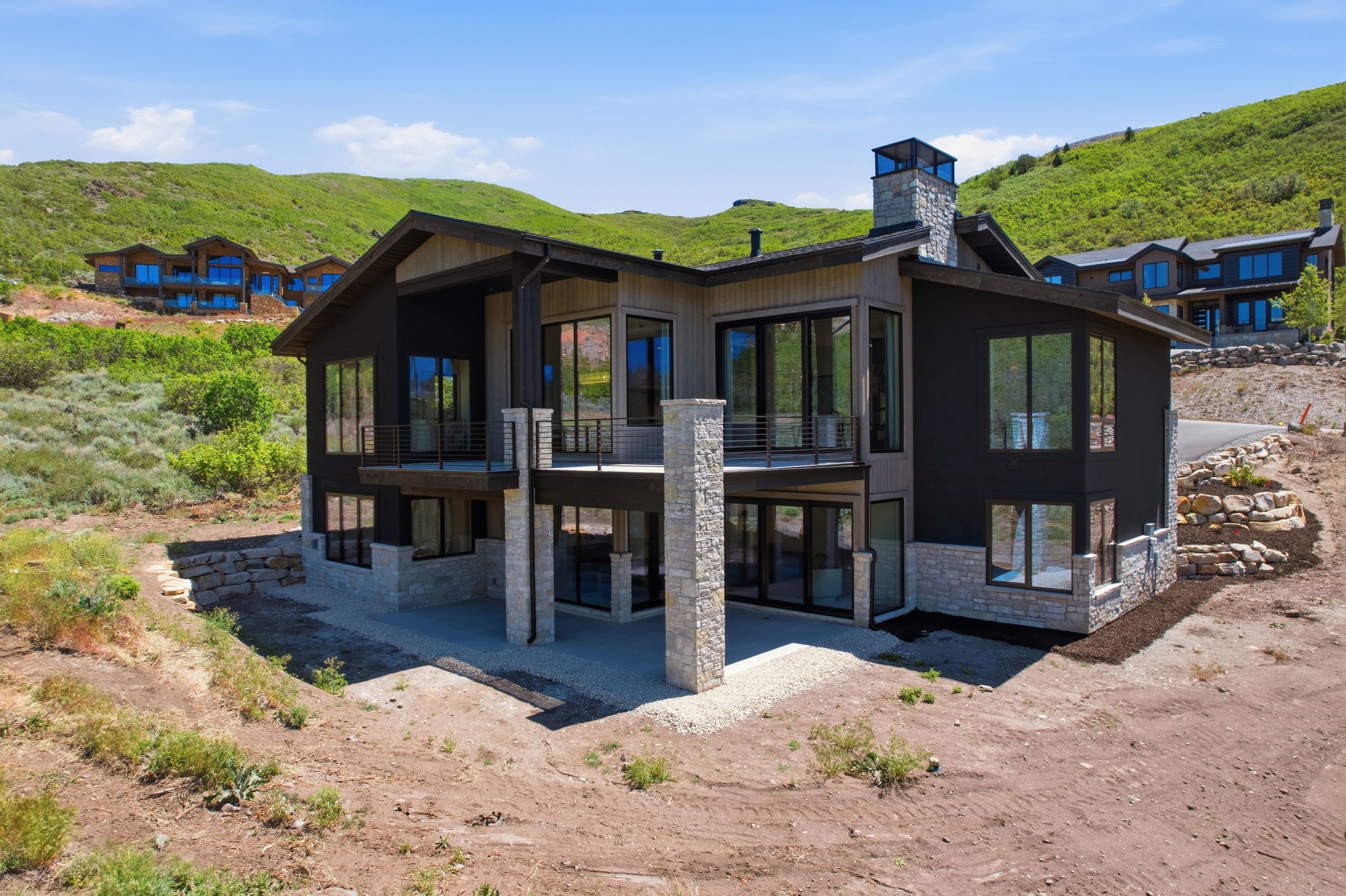 Modern mountain residence featuring a multi-level design, extensive window placement, and stone accents