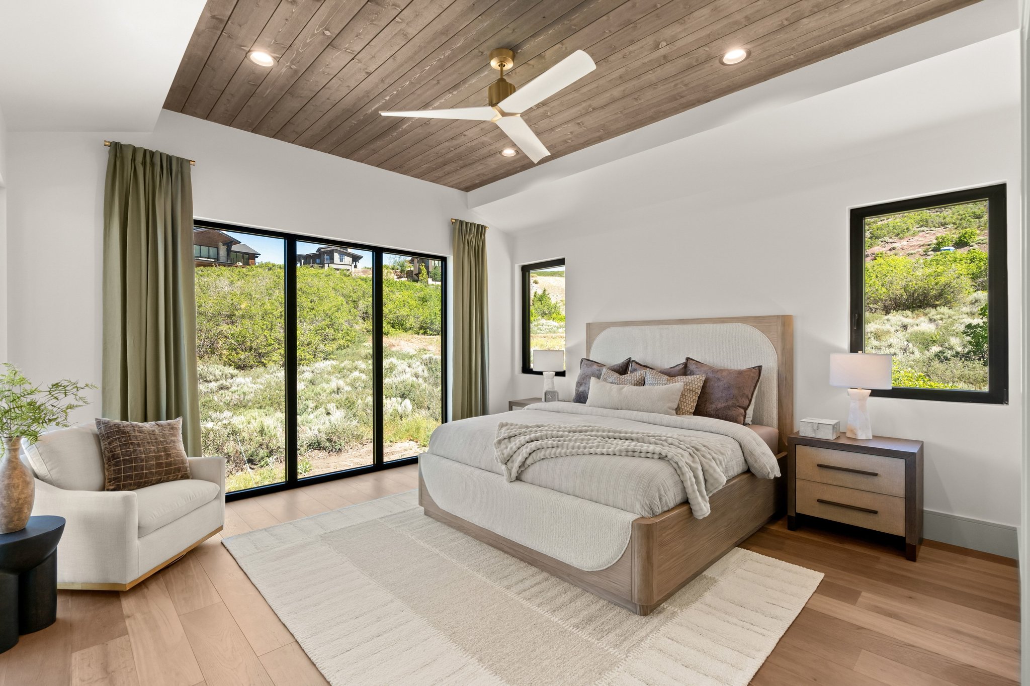 Spacious room featuring a tray ceiling with wood-finish paneling, a contemporary ceiling fan, and recessed lighting