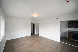 Spacious room with wood-finish flooring, white walls, and a recessed ceiling light fixture