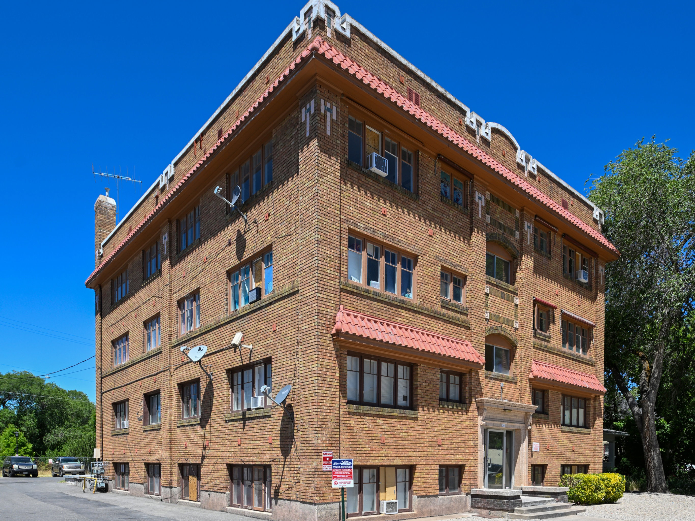 Four-story brick building with architectural detailing, multiple windows, and a prominent main entrance