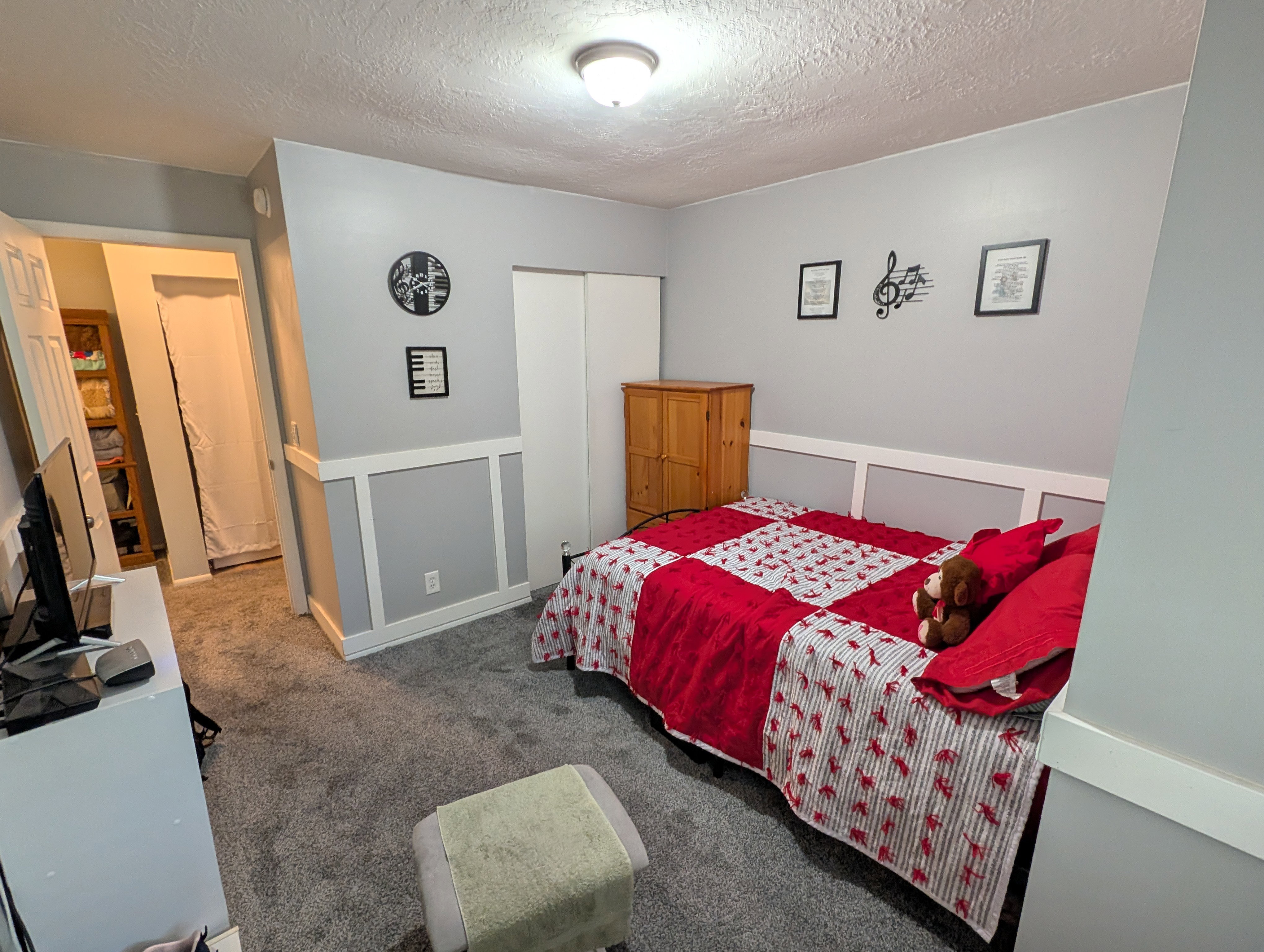 Room featuring light gray walls with wainscoting, gray carpet flooring, and a flush mount ceiling light