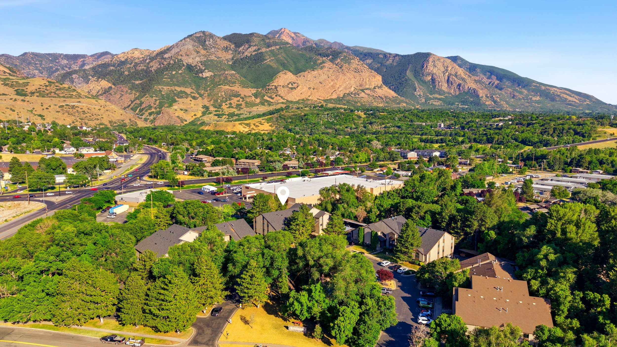 Aerial perspective showcasing a residential area nestled at the base of extensive mountain ranges