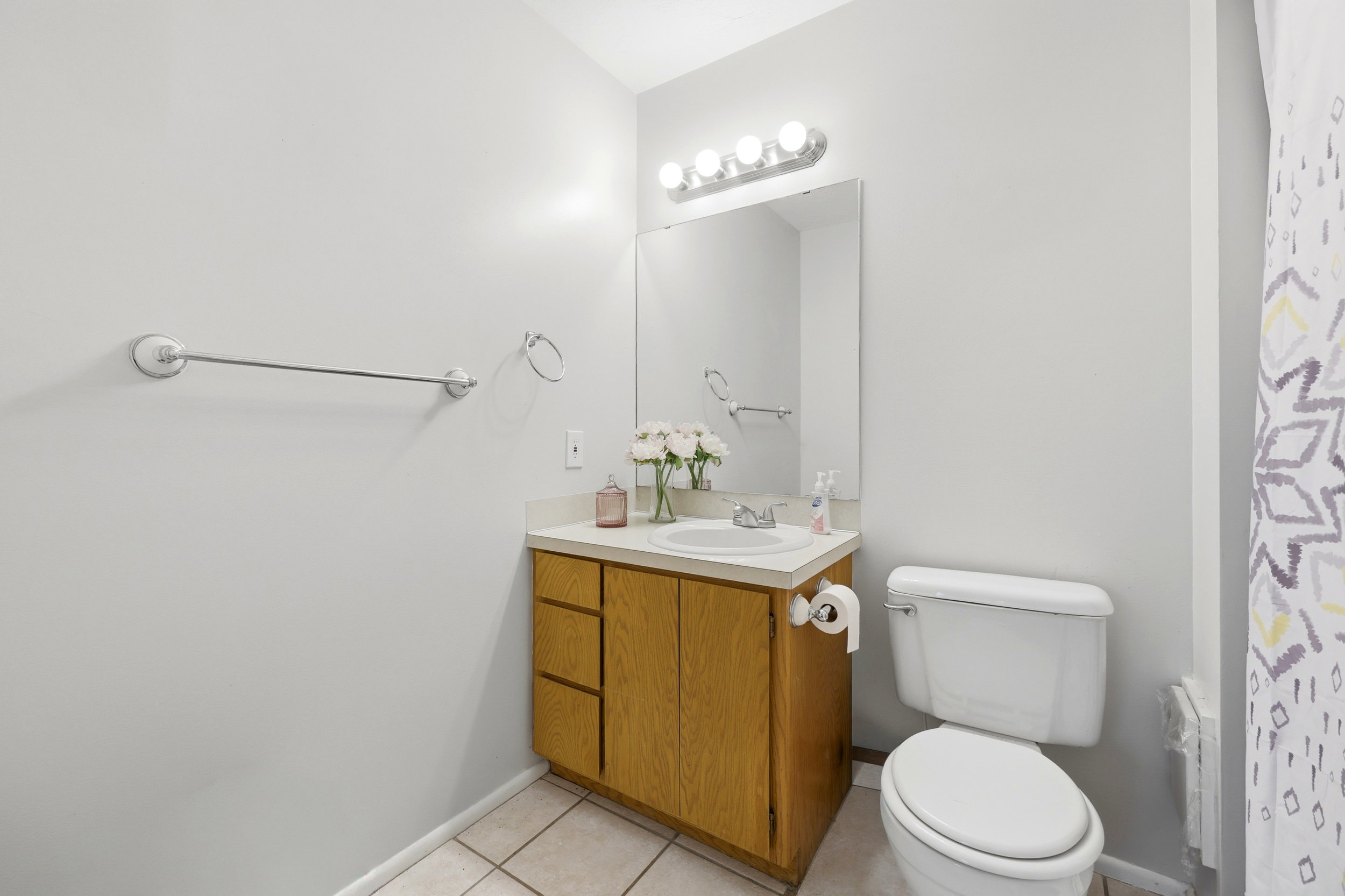 Bathroom featuring a wooden vanity with a laminate countertop, an integrated sink, and chrome fixtures