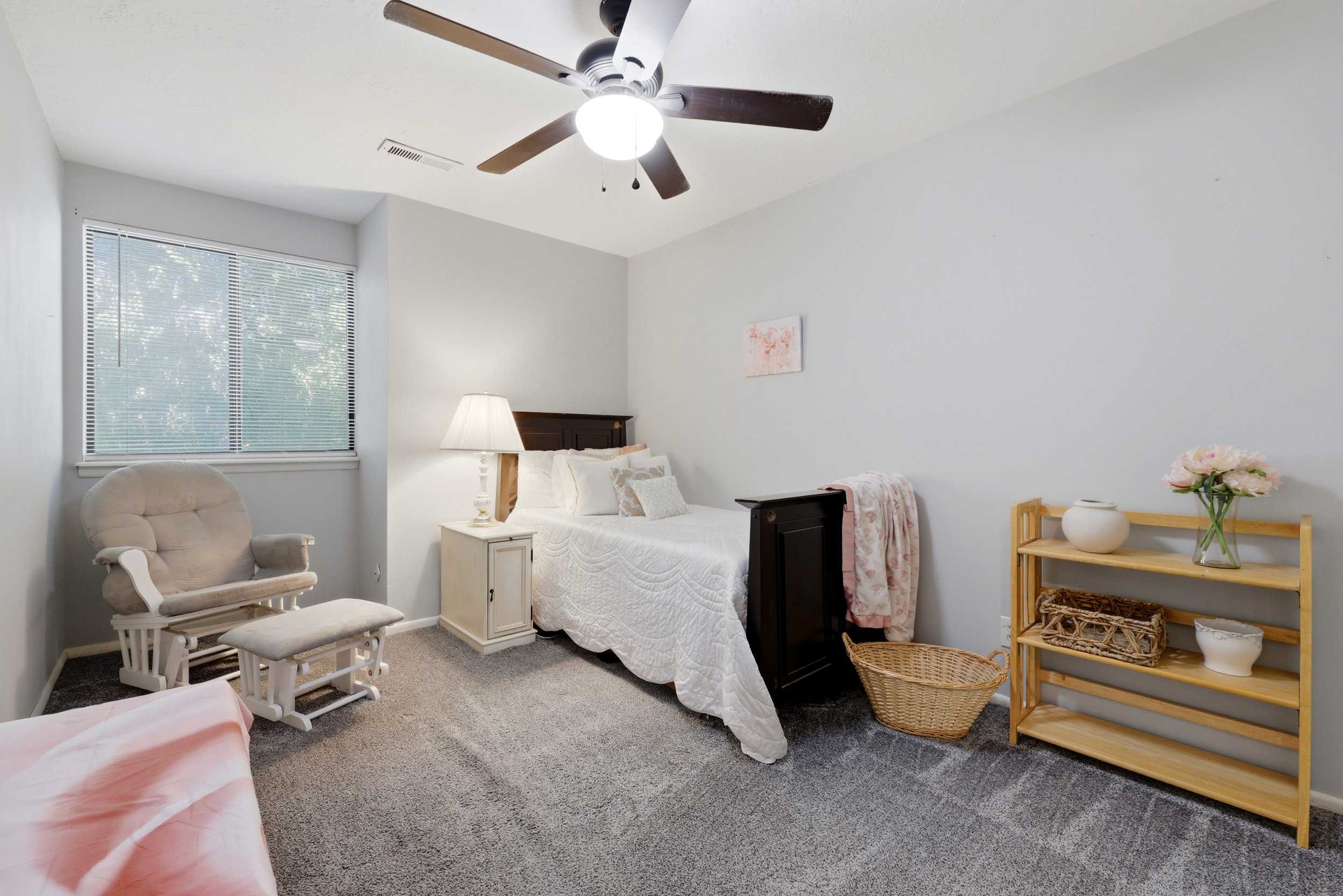 Carpeted room featuring a ceiling fan with integrated lighting, a window with blinds, and light-toned walls