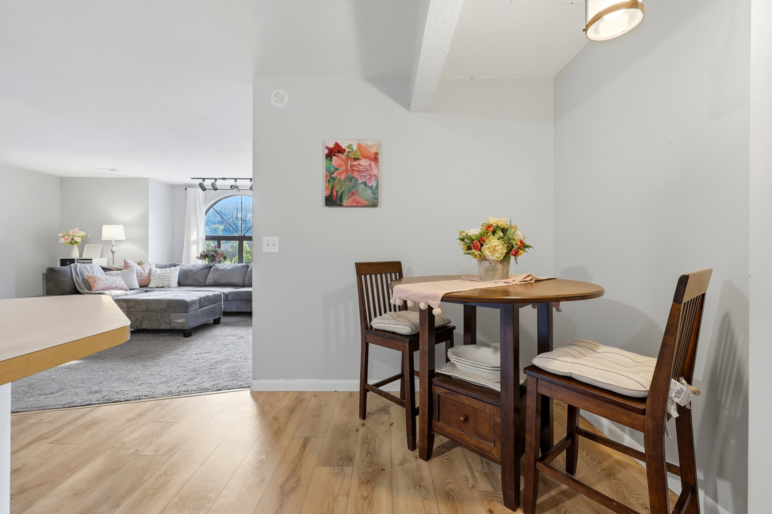 Dining nook featuring wood-finish flooring, a contemporary ceiling light fixture, and light gray wall paint