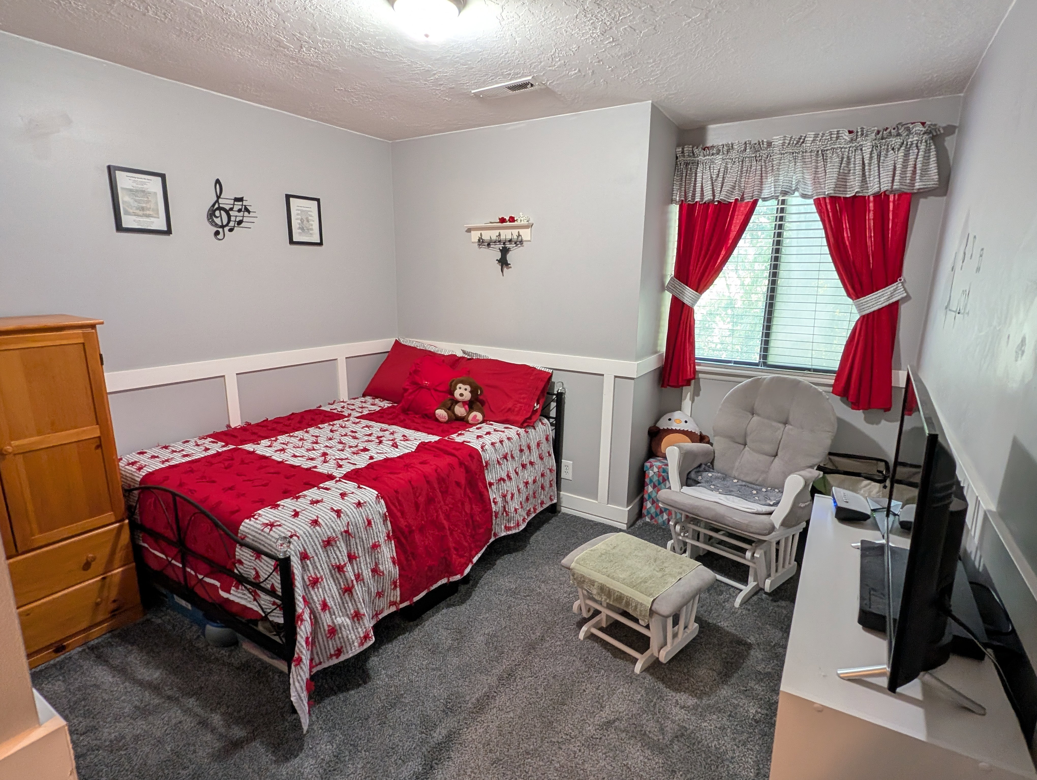 Bedroom featuring wainscoting detail, a window with blinds, and dark gray carpeting