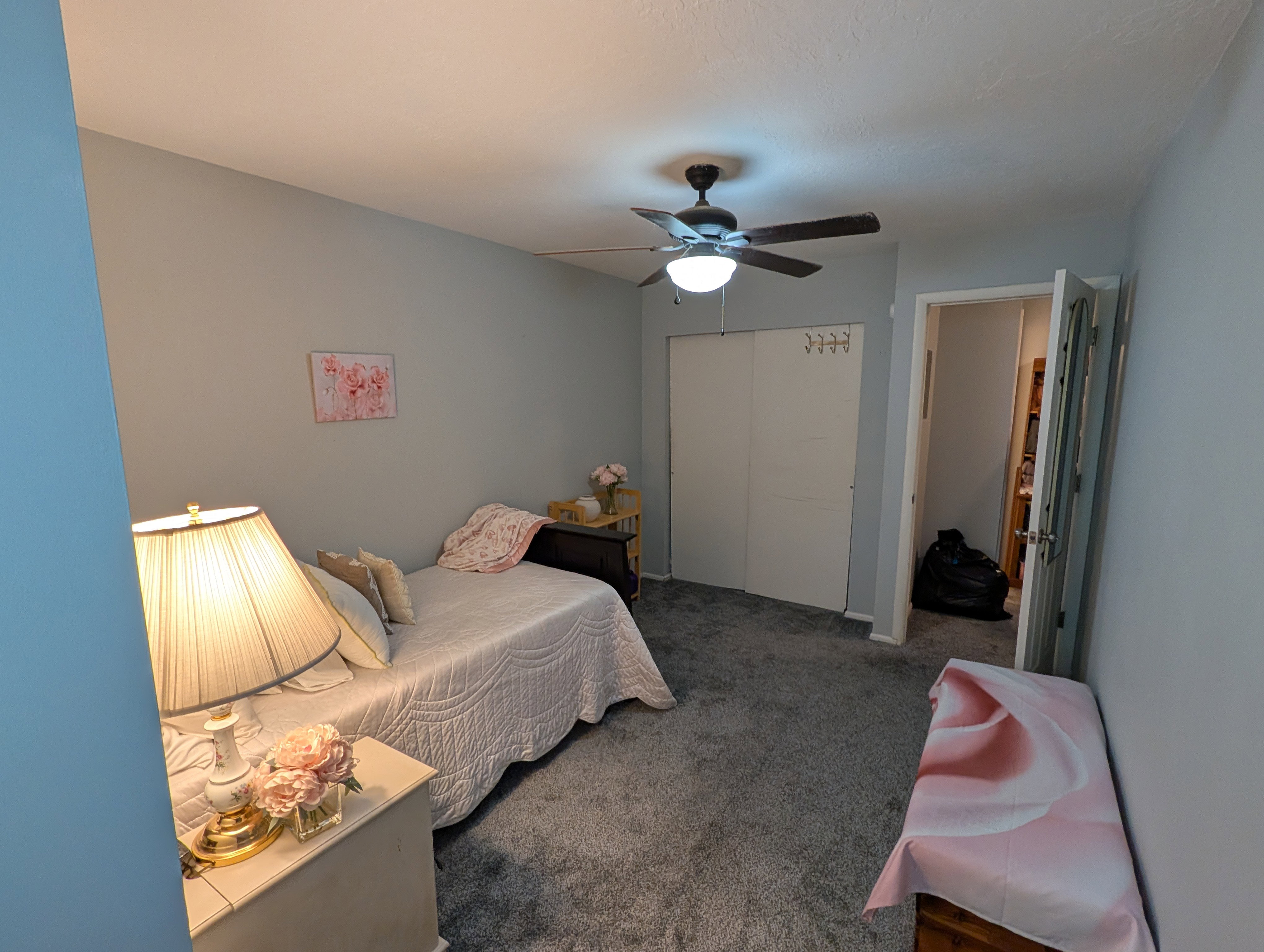 Bedroom featuring soft gray wall paint, gray carpet flooring, and a ceiling fan with integrated lighting