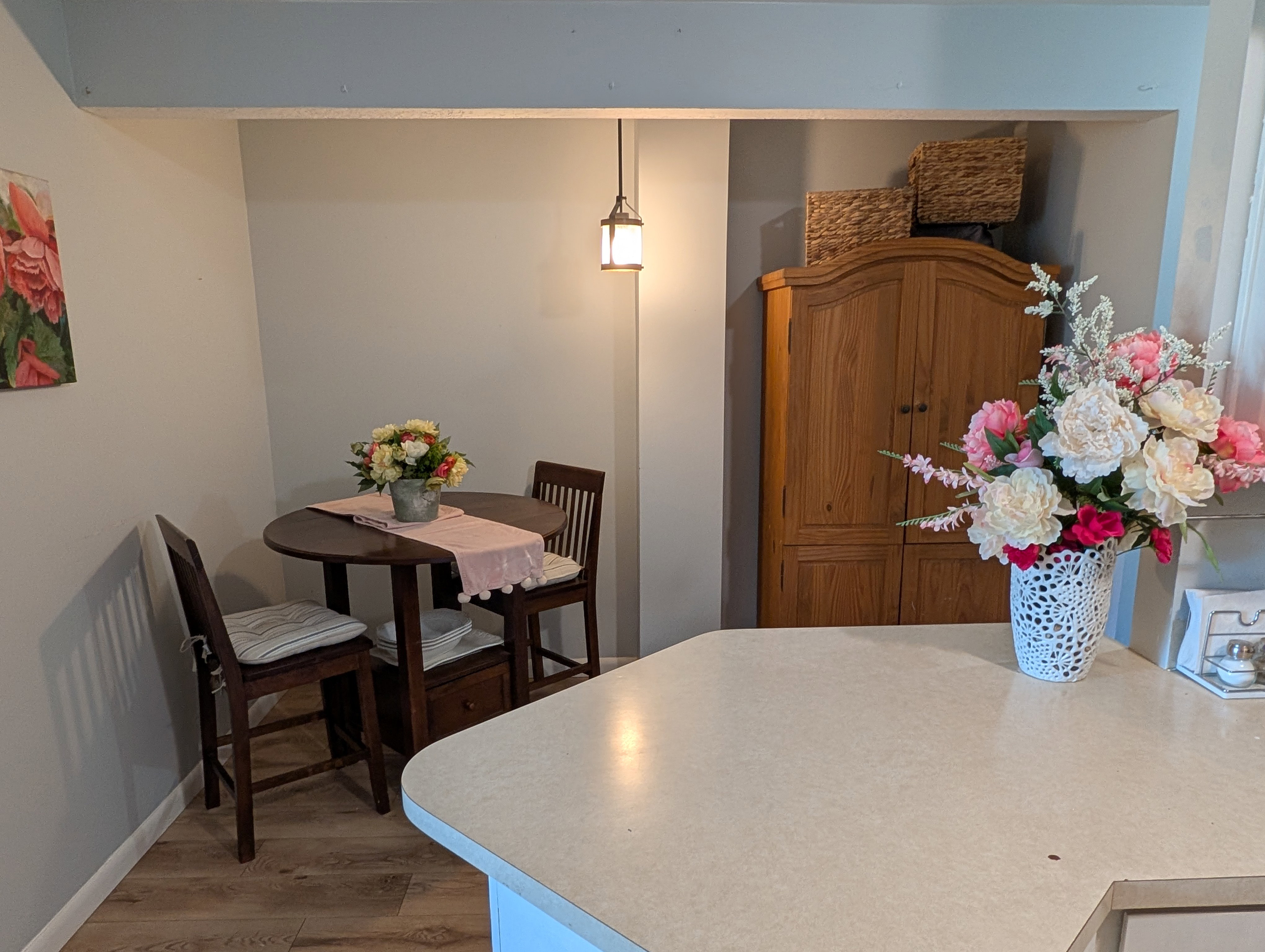 Compact dining area featuring wood-finish flooring and a contemporary pendant light fixture