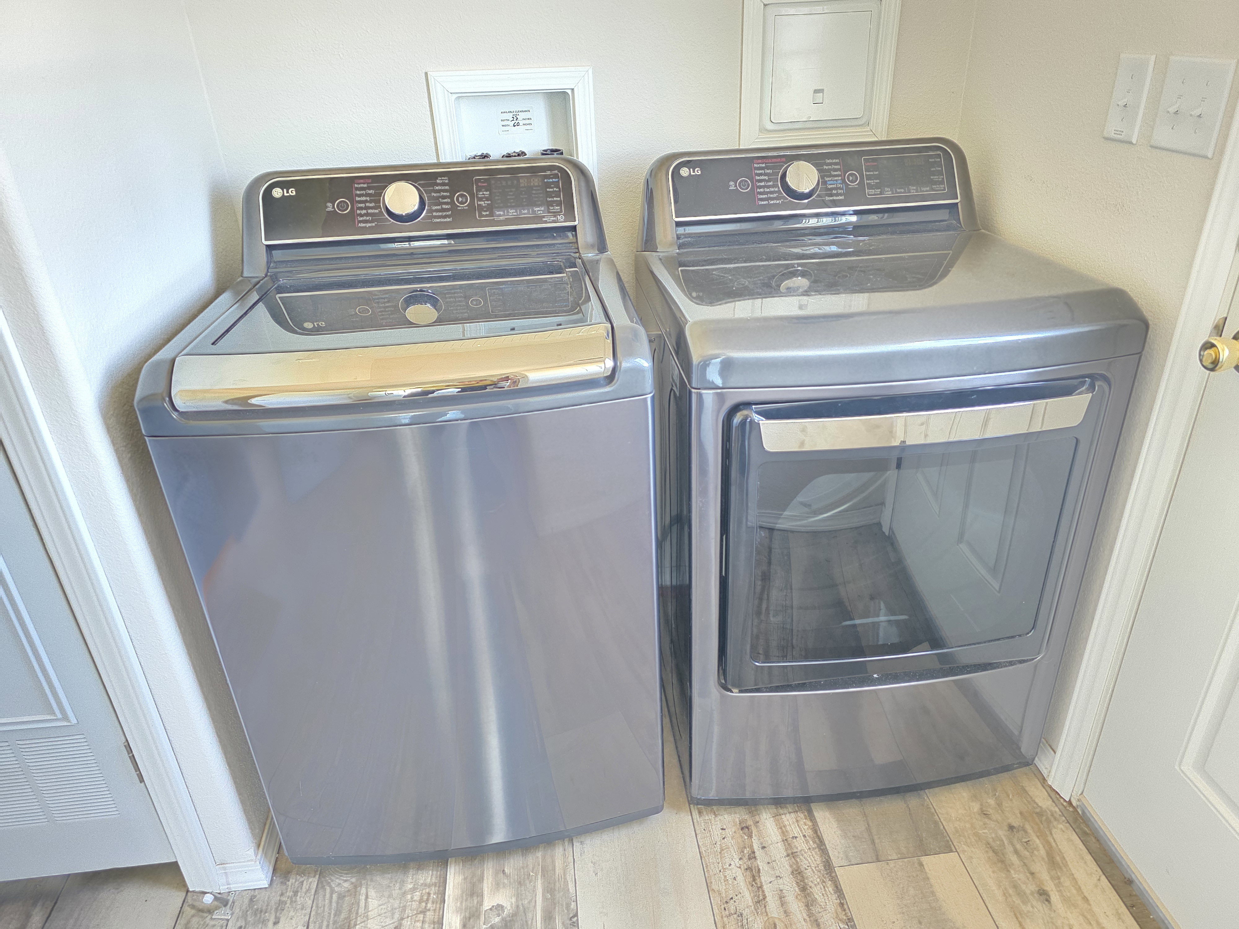 Dedicated laundry area featuring wood-finish flooring and light-toned walls