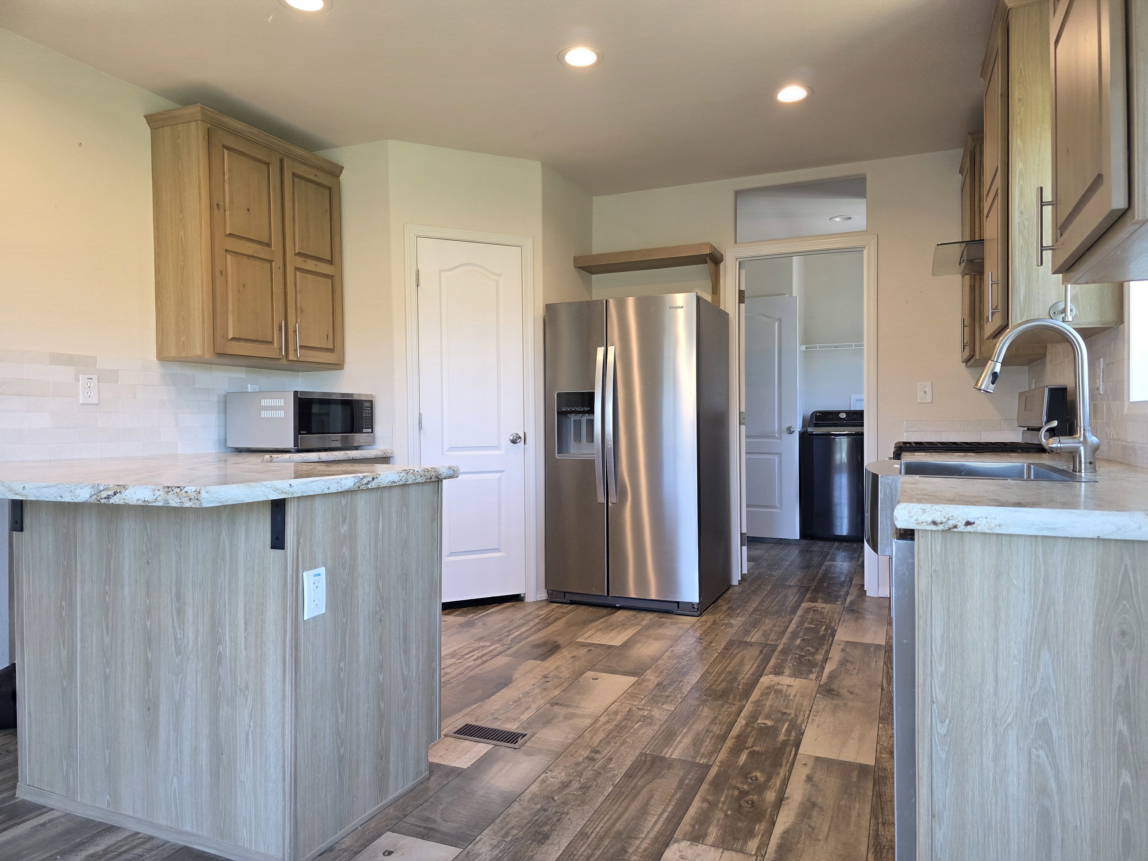 Kitchen featuring wood-finish flooring and light-toned cabinetry