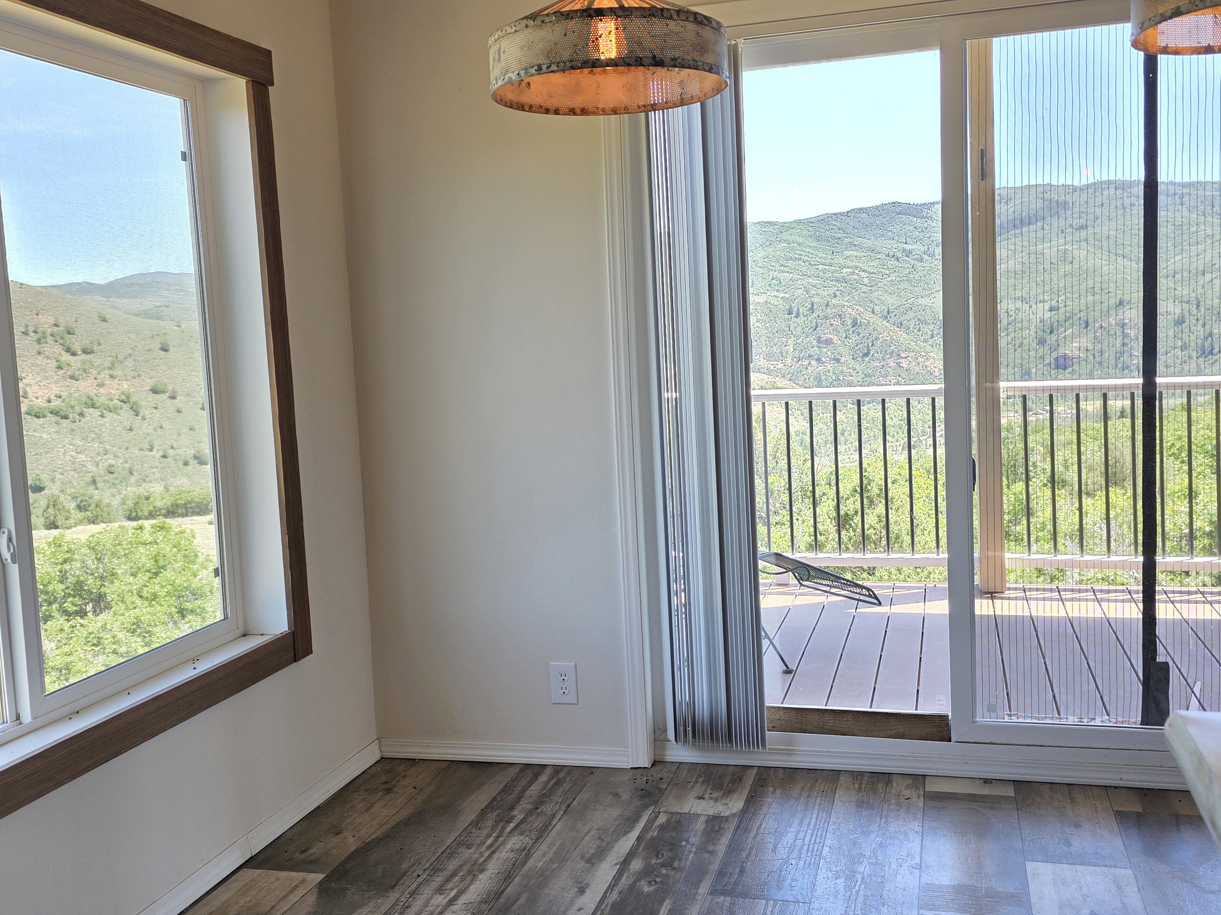 Expansive sliding glass doors open to an outdoor deck with metal railing