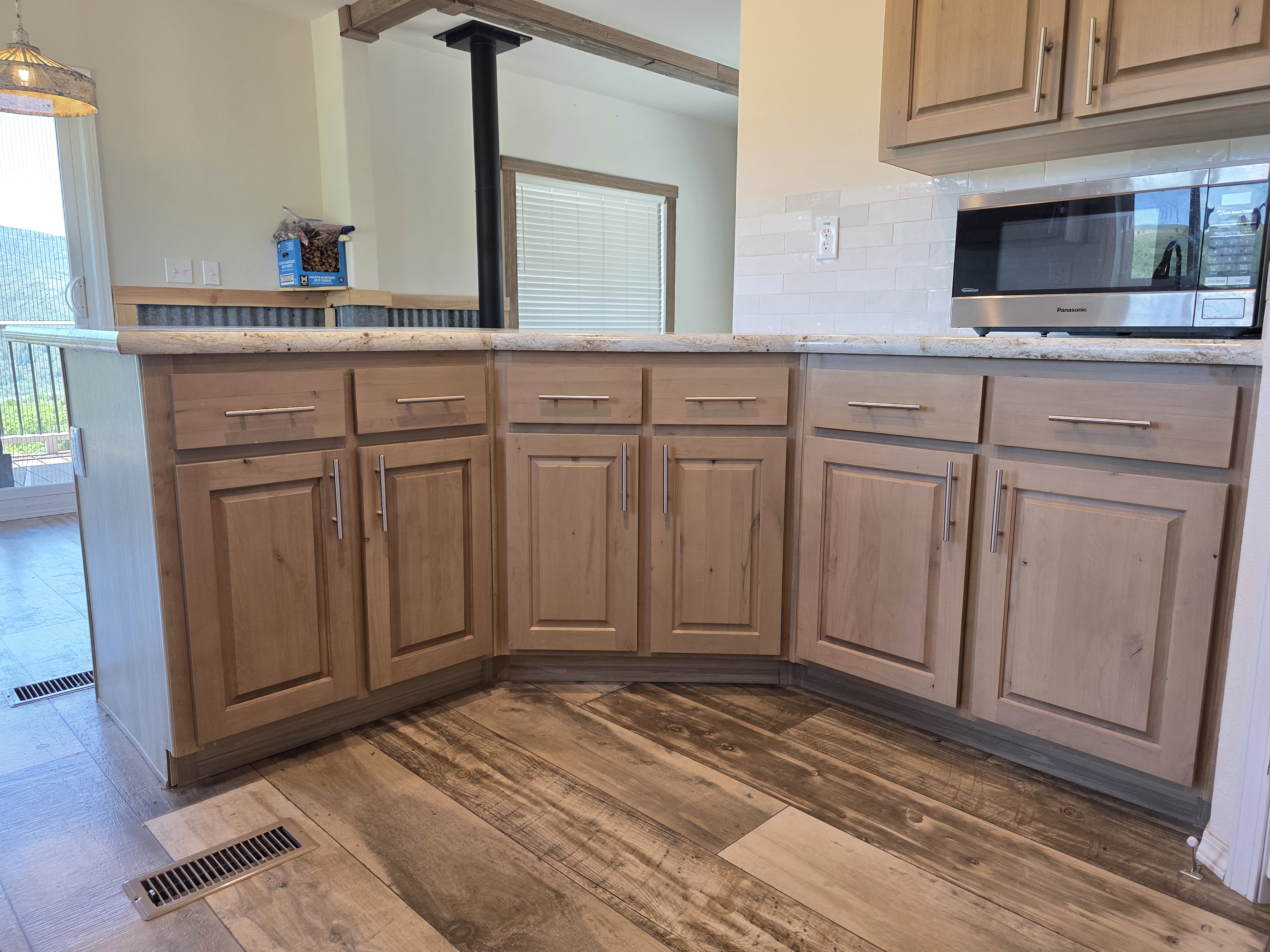 Wood-finish flooring complementing light-toned cabinetry with brushed nickel hardware