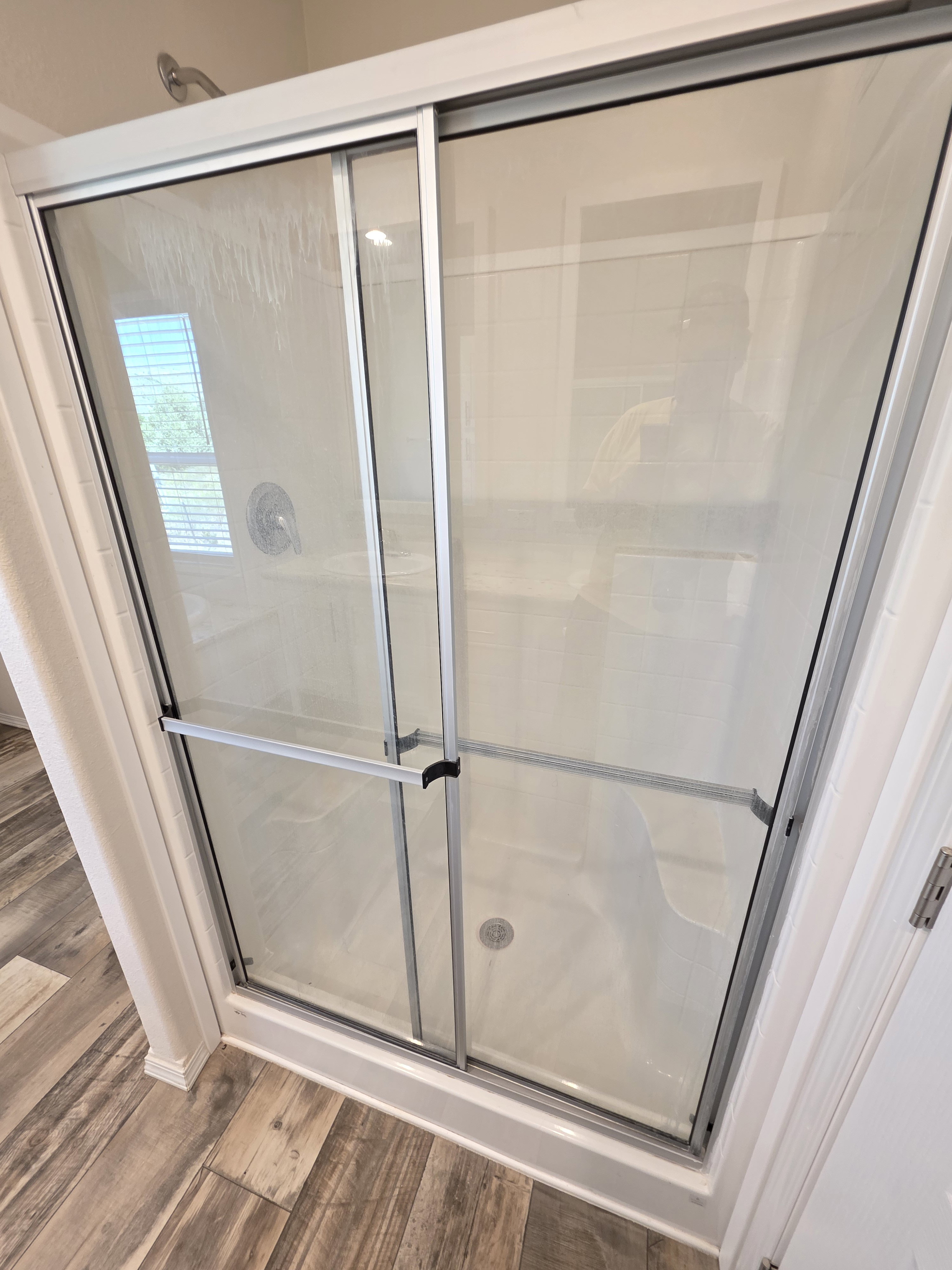 Framed glass shower enclosure with sliding doors