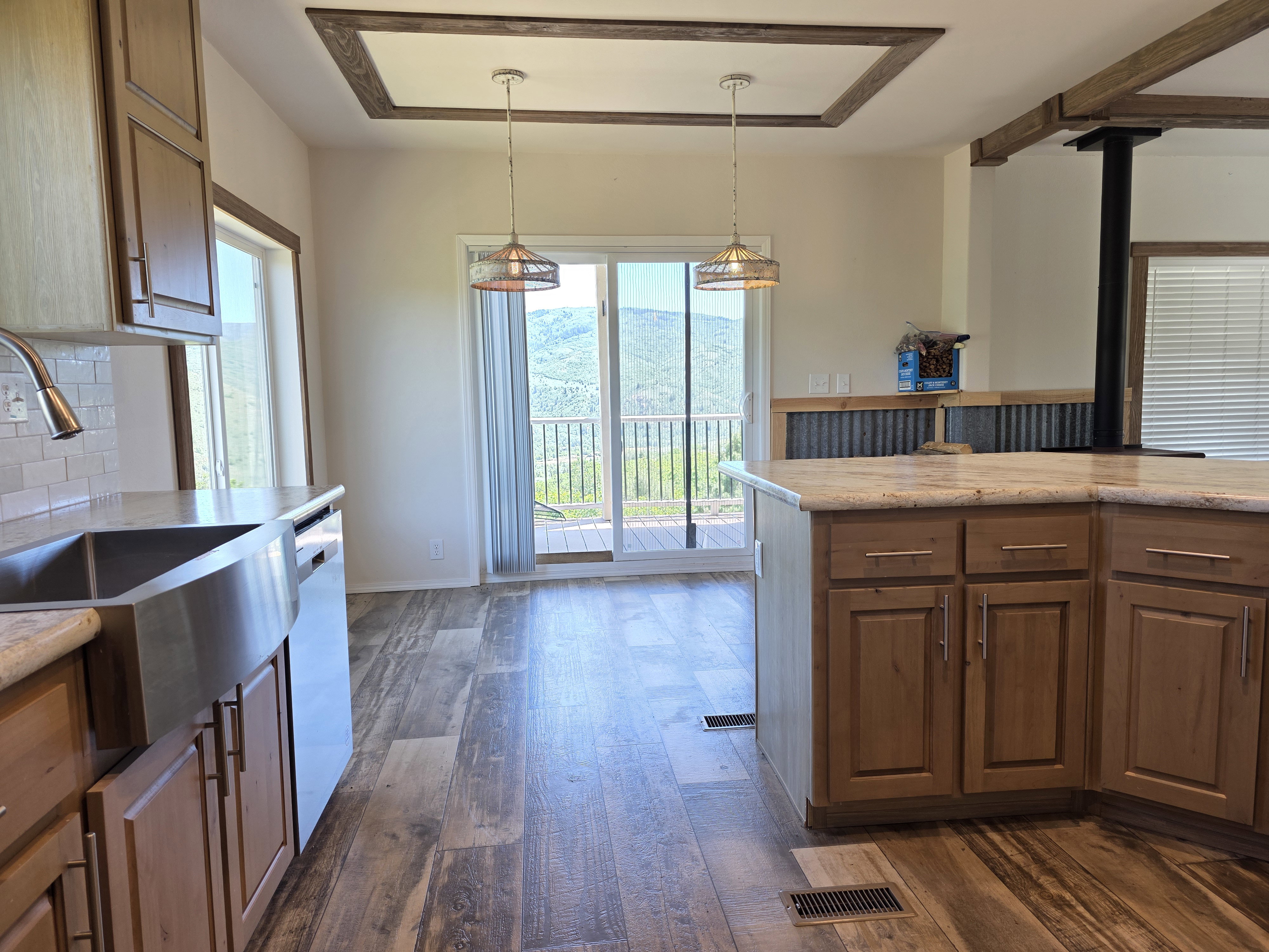 Kitchen featuring wood-finish flooring, light cabinetry, stone countertops, and a stainless steel farmhouse sink