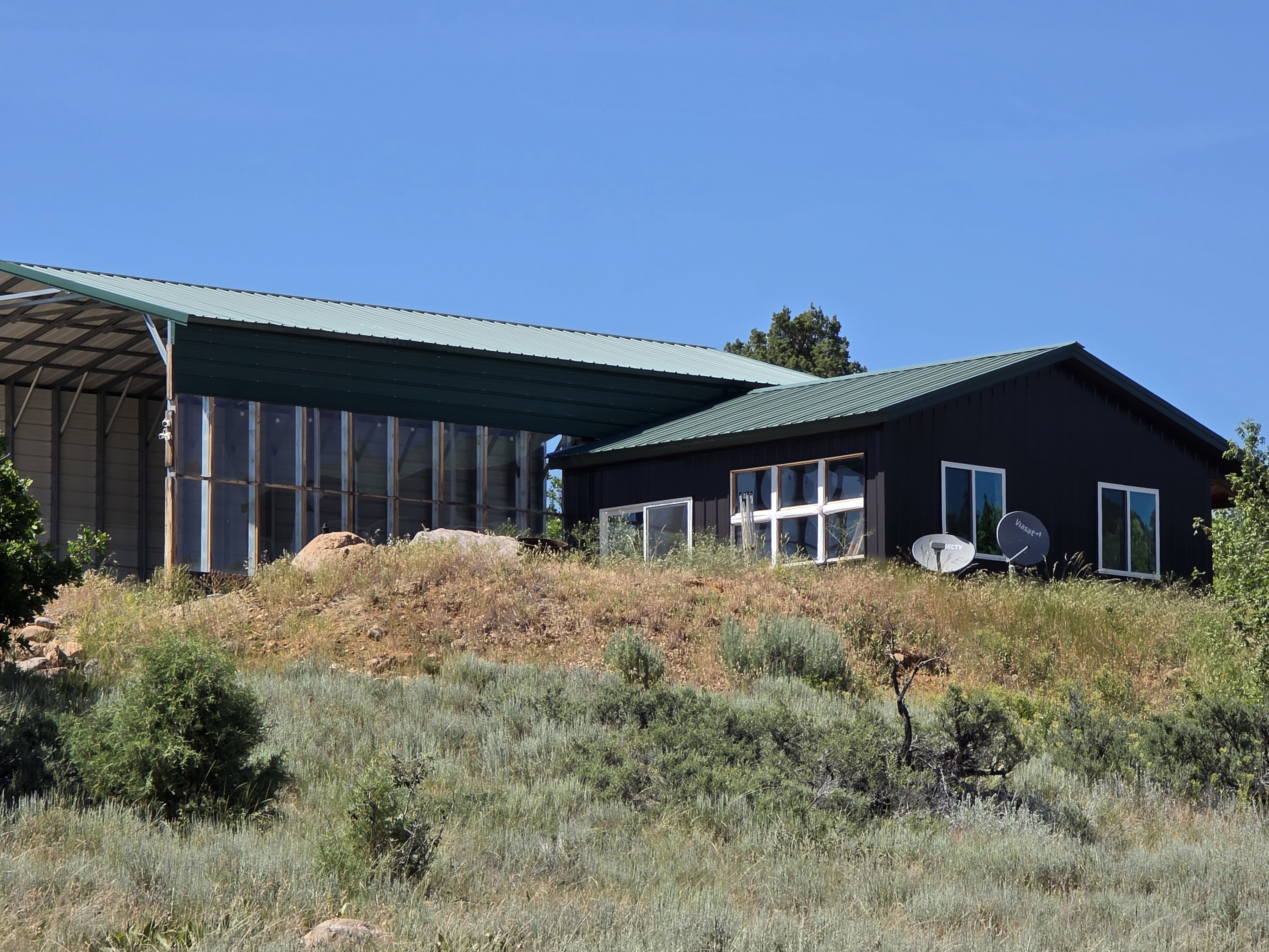Dark-paneled exterior with a green metal roof, Open RV, Boat, Toy Storage on the left.