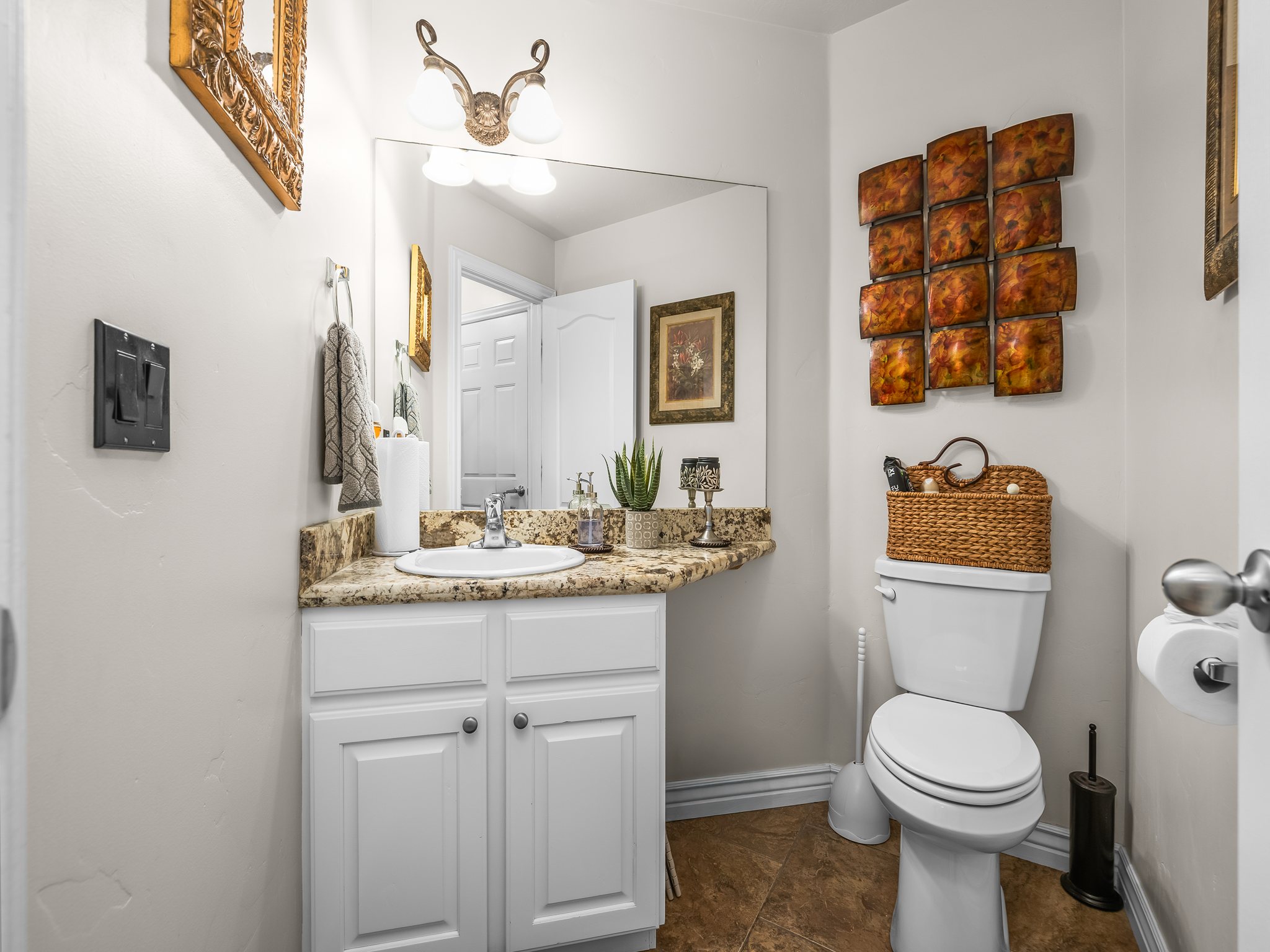 Bathroom featuring a white vanity with panel cabinetry and a granite-finish countertop